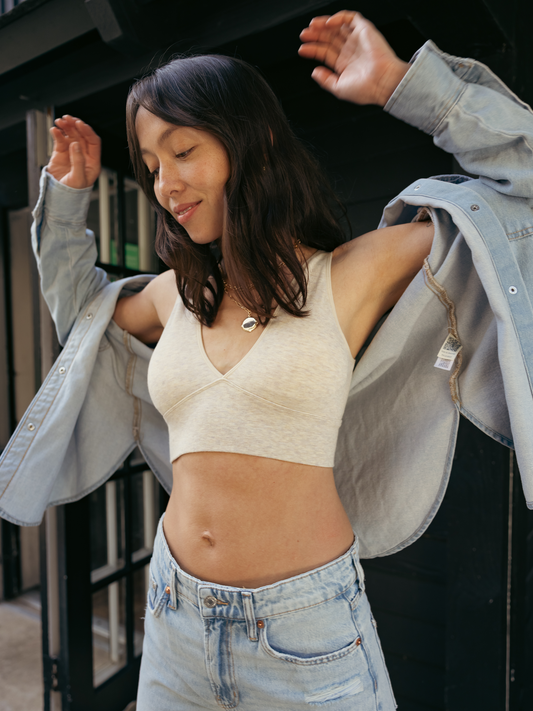 Model outside wearing the Sublime® Bamboo Maternity & Nursing Plunge Bra in Oatmeal heather, paired with a denim shacket and jeans. @model_info:Lyn in wearing a Small.