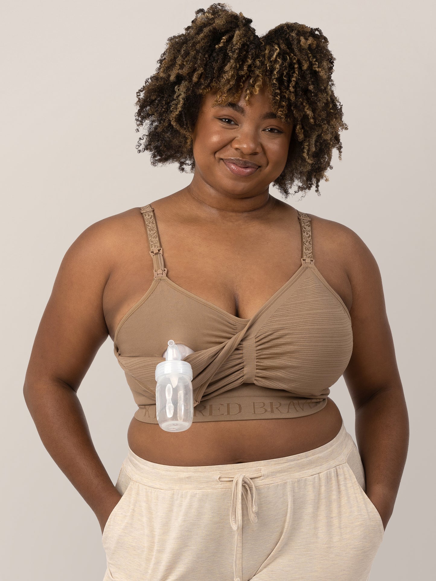 Model wearing the Sublime® Hands-Free Pumping & Nursing Bra in Latte, demonstrating the clip down nursing and pumping access