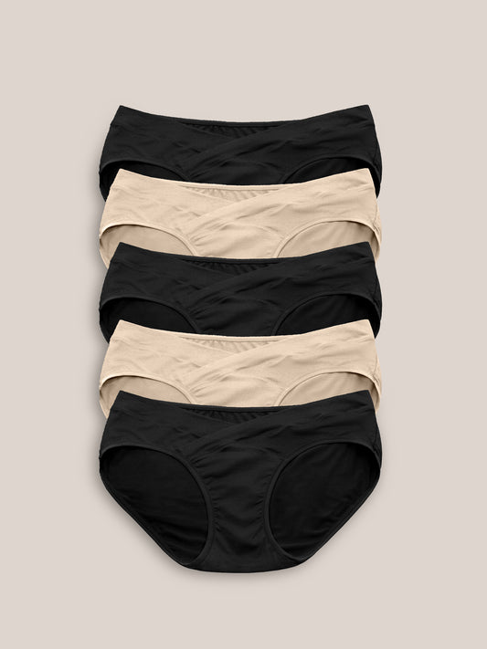 Flat lay of the Under-the-Bump Bikini Underwear Pack | Low Rise Style - Neutrals against a greige background. 