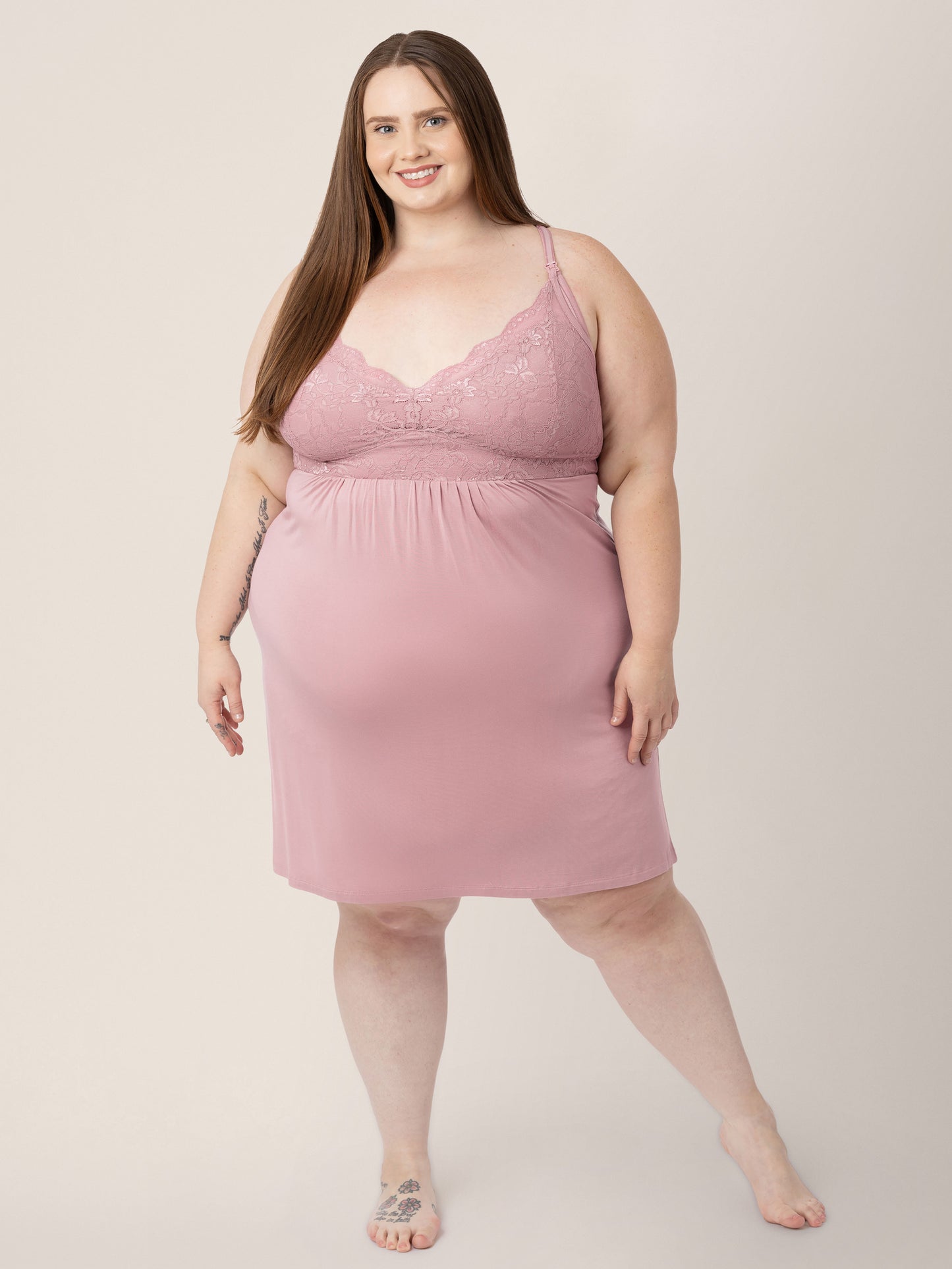 Model standing with her weight more on one leg than the other with her hands at her side while wearing the Lucille Maternity & Nursing Nightgown in Vintage Pink.