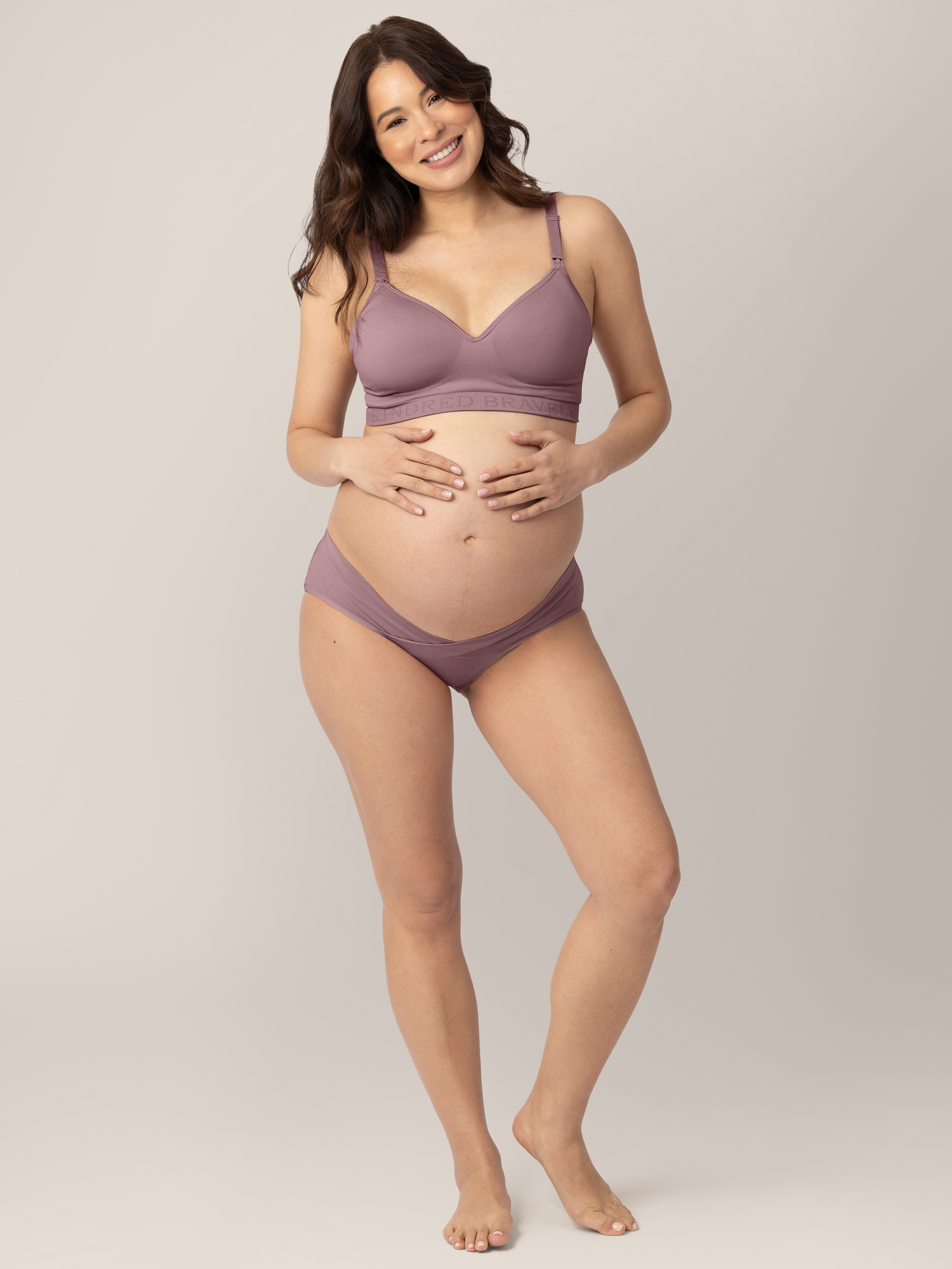 Pregnant model wearing the Under-the-Bump Bikini Underwear in assorted colors holding her belly. @model_info:Vanessa is wearing a Small. 