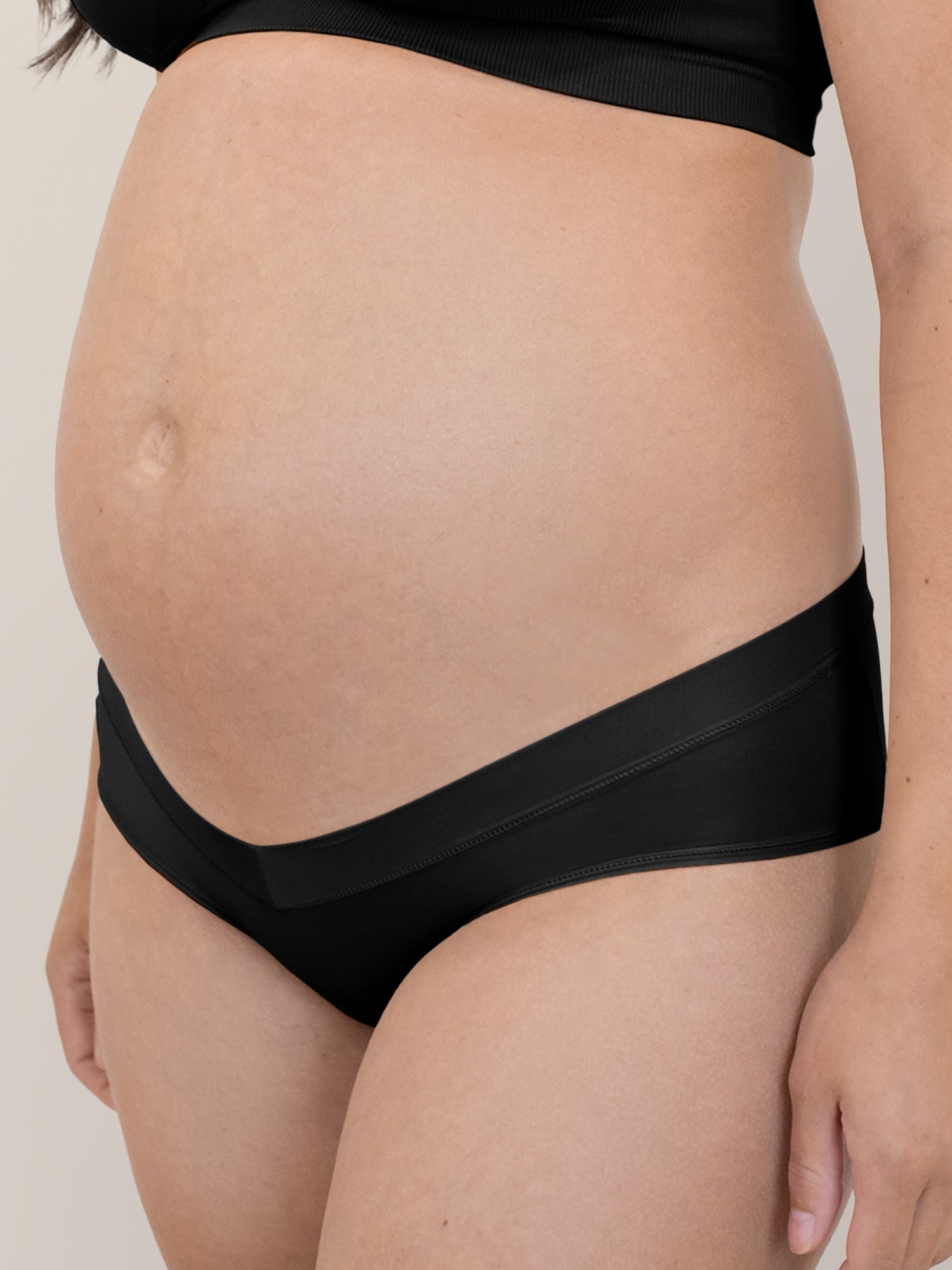 Closeup of a pregnant model wearing the Grow with Me™ Maternity & Postpartum Hipster in Black
