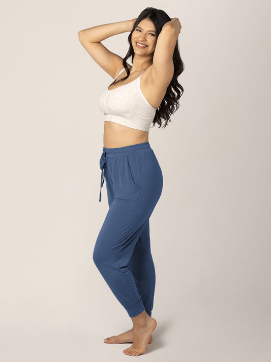 Model with her hands in her hair wearing the Everyday Lounge Jogger in Slate Blue @model_info:Nohely is 5'4" and wearing a Medium Regular.