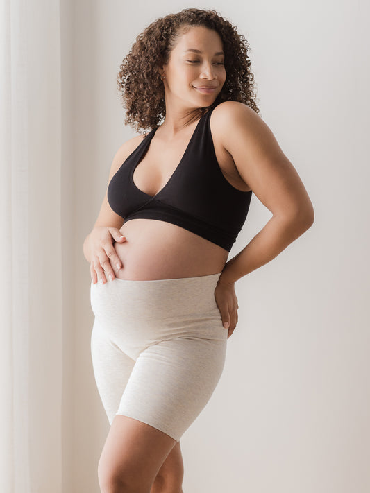 Pregnant model wearing the Sublime® Bamboo Maternity & Postpartum Bike Short in oatmeal heather, paired with the Sublime® Bamboo Maternity & Nursing Plunge Bra in black@model_info:Alysha is 5'6" and wearing a Large.