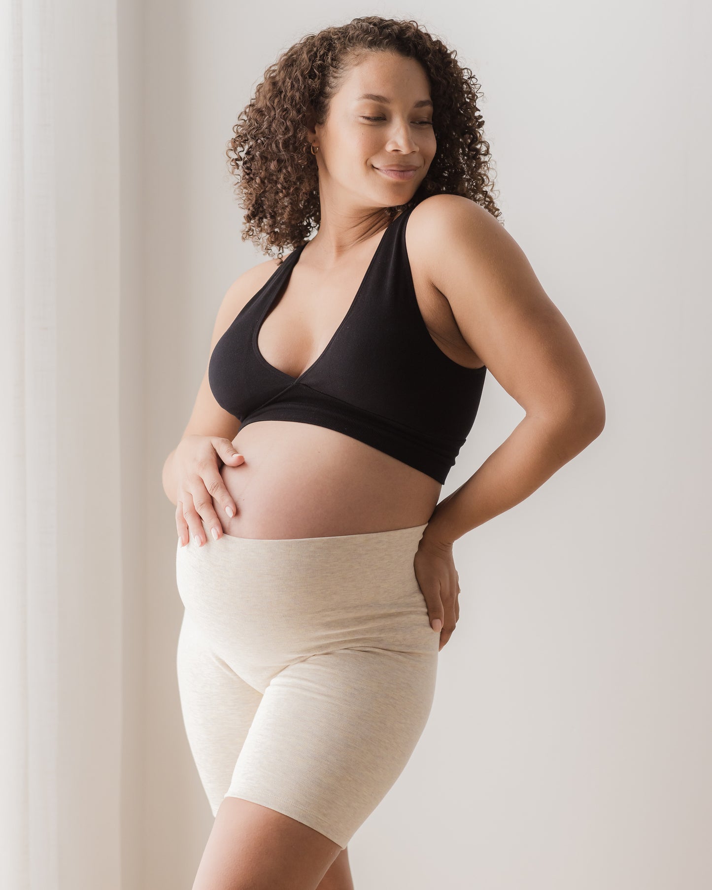 Pregnant model wearing the Sublime® Bamboo Maternity & Postpartum Bike Short in oatmeal heather, paired with the Sublime® Bamboo Maternity & Nursing Plunge Bra in black@model_info:Alysha is 5'6" and wearing a Large.