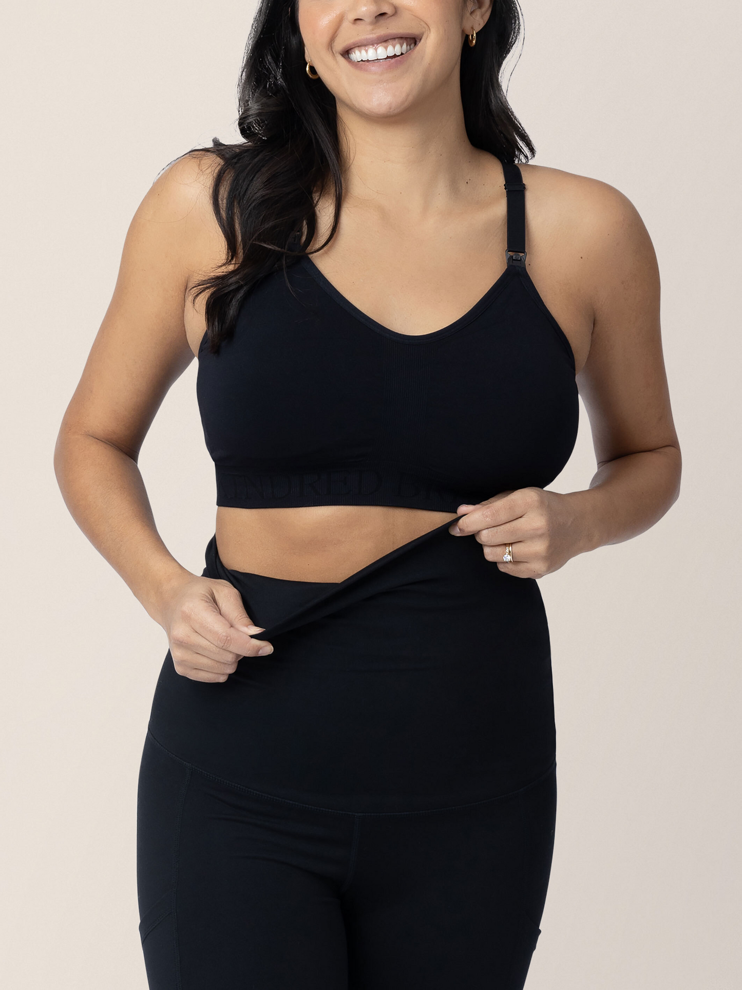 Closeup of a model wearing the Louisa Maternity & Postpartum Legging in Black with pockets.