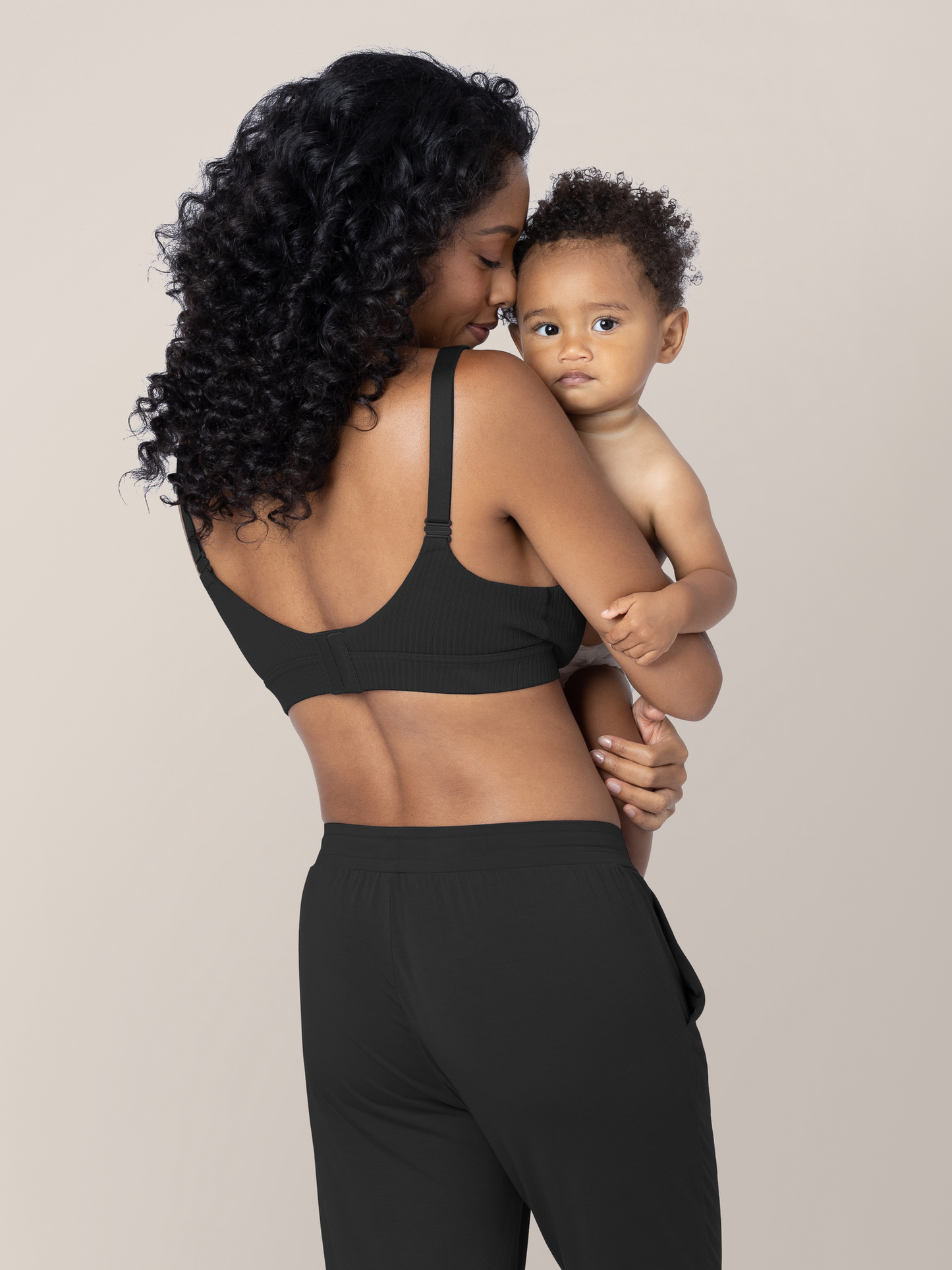 Back view of a model with her baby wearing the Ribbed Cotton Maternity & Nursing Bra | Black