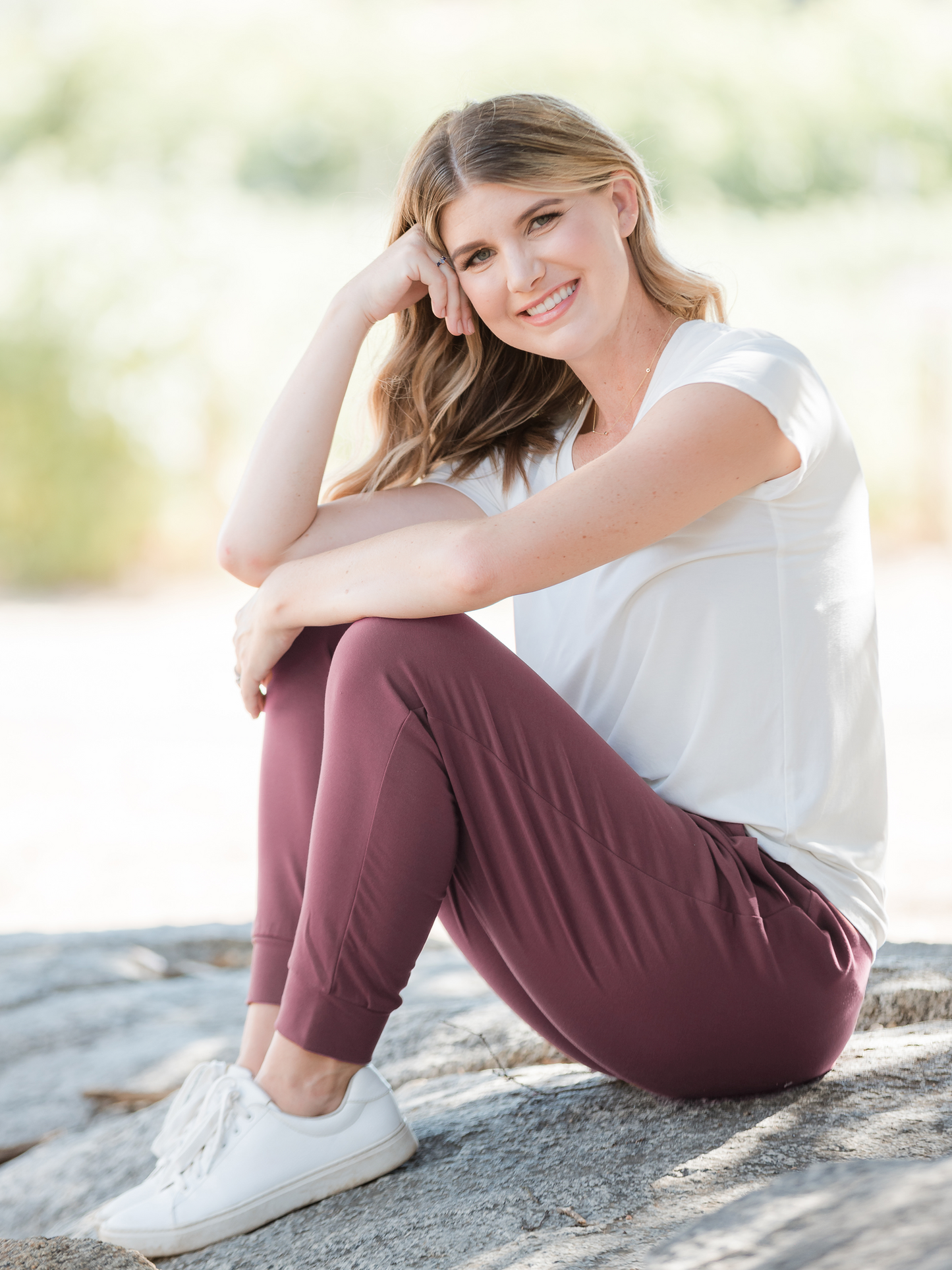 Model sitting on a rock while wearing the Bamboo Everyday T-shirt in White