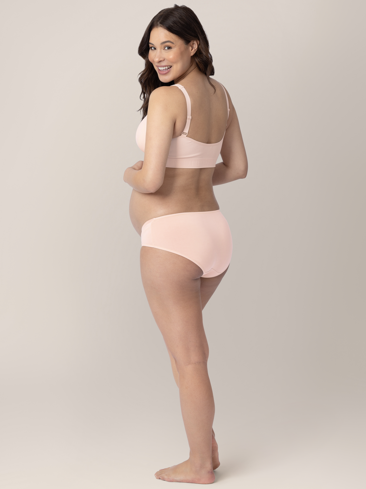 Back view of a pregnant model wearing the Under-the-Bump Bikini Underwear in assorted colors 