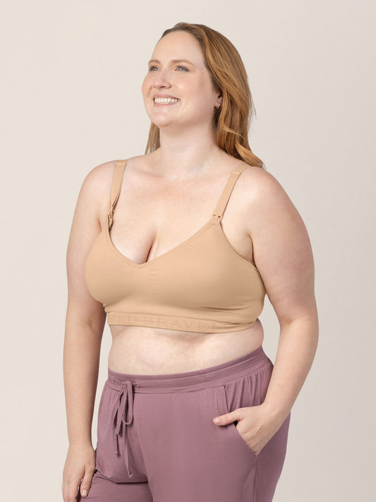 Model wearing the Signature Sublime® Contour Hands-Free Pumping & Nursing Bra in Beige with her hand in her pocket.@model_info:Ryn is wearing an X-Large Busty.