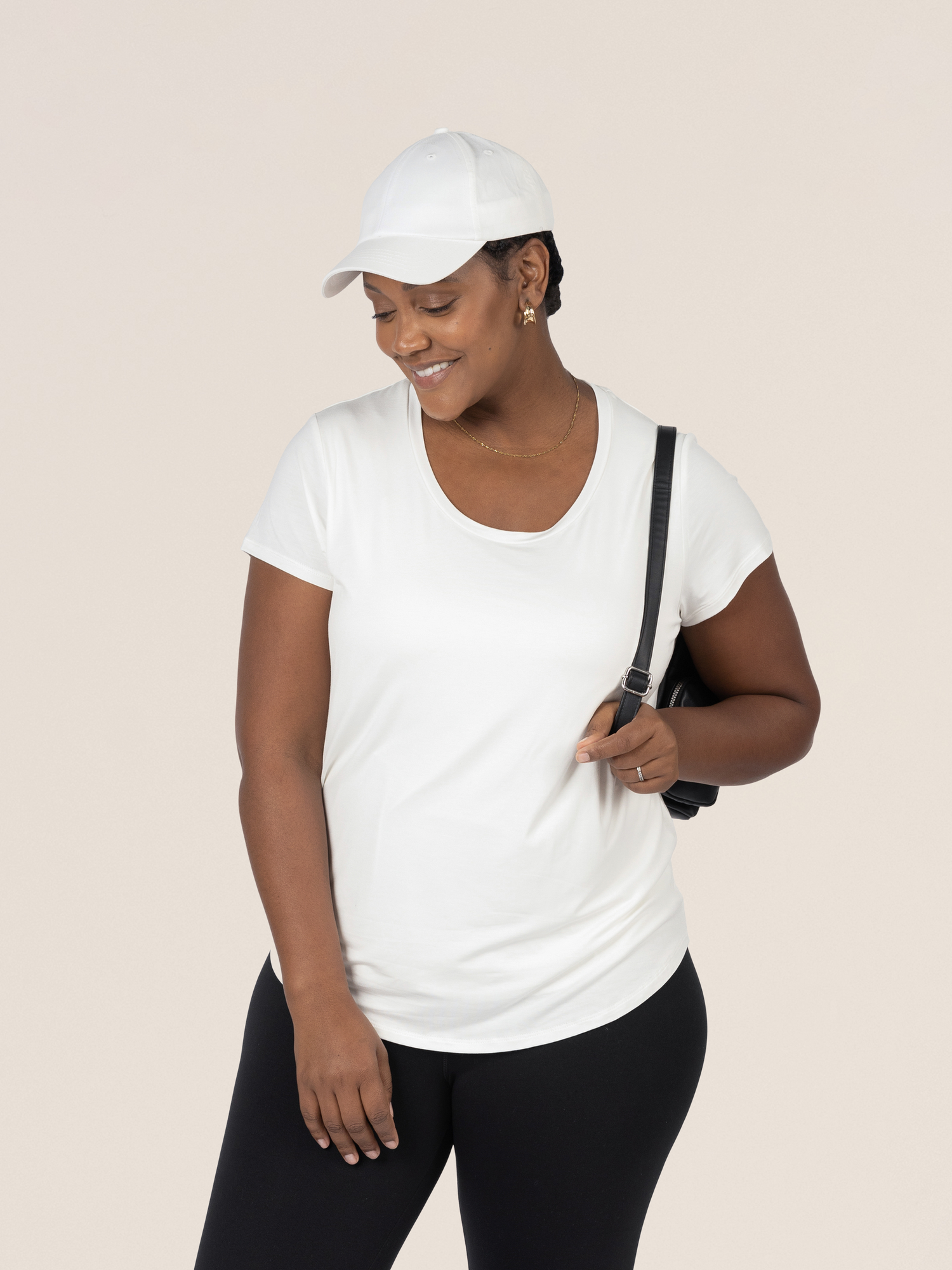 Model looking down while wearing the Everyday Maternity & Nursing T-shirt in White  in a baseball cap.