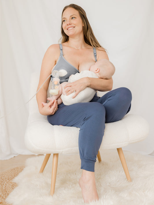 Model breastfeeding her baby while pumping  and wearing the Sublime® Hands-Free Pumping & Nursing Bra in Grey @model_info:Ali is wearing a Large Busty.