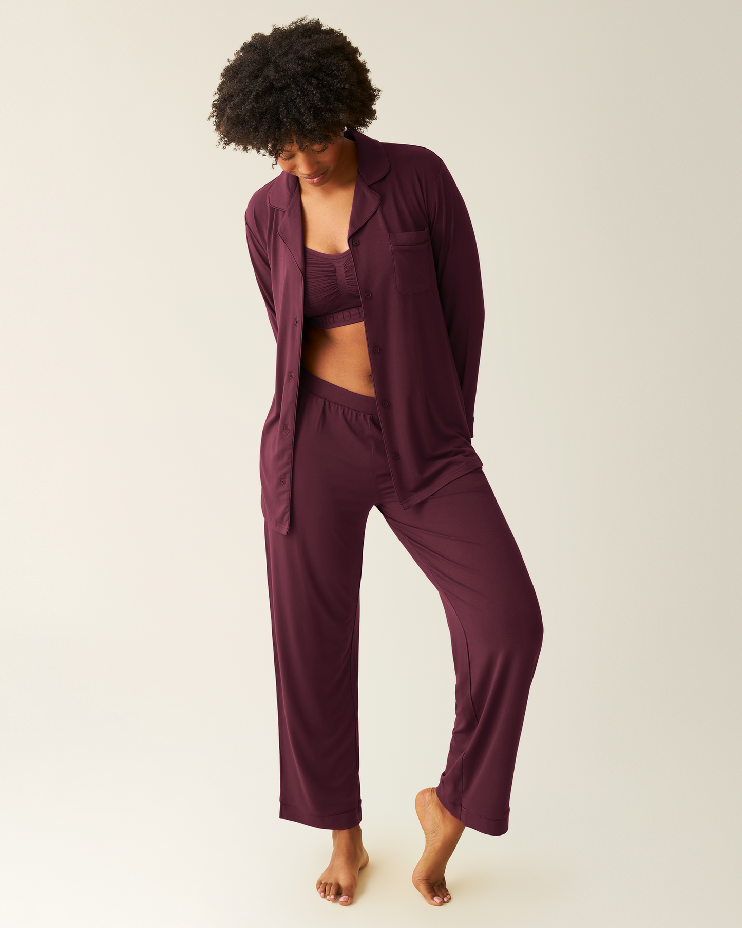 Woman wearing the Clea Bamboo Long Sleeve Pajama Set in Deep Burgundy, with top open, paired with matching Sublime bra