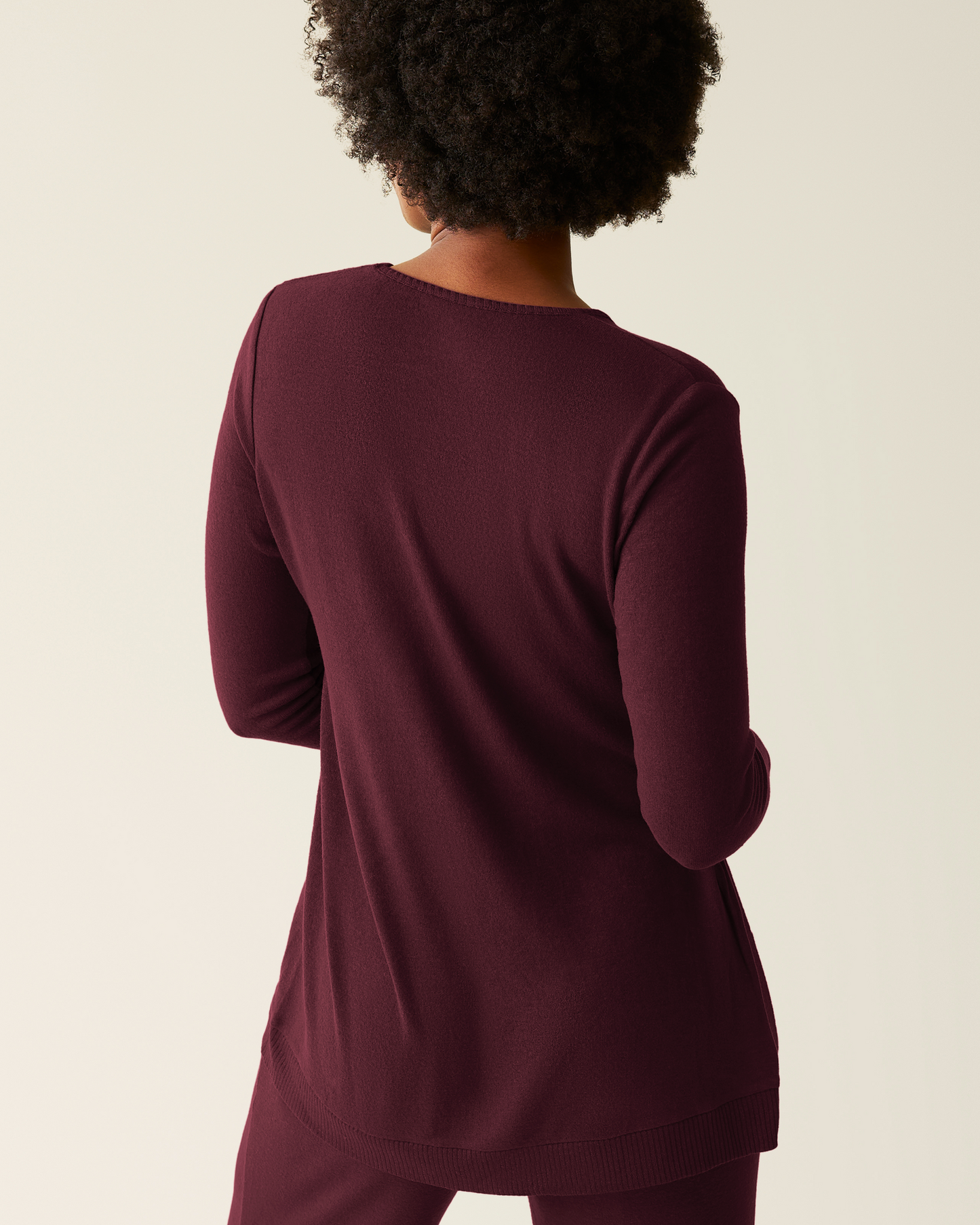Person wearing CozyKnit Maternity & Nursing V-neck Top in Deep Burgundy with matching pants on a beige background