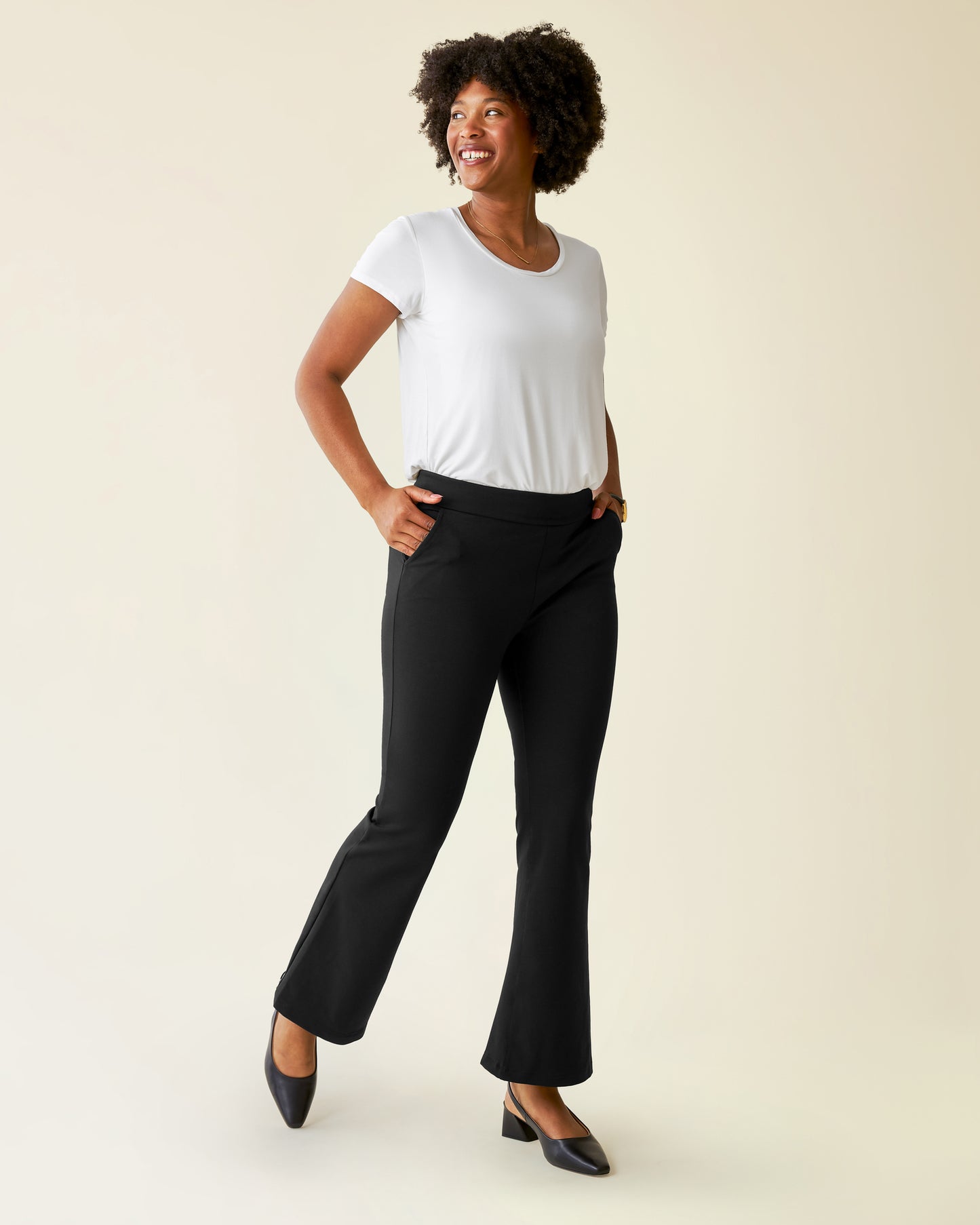 Woman wearing the Ponte Flare Pant with a white top@model_info:Kyra is wearing a Small.
