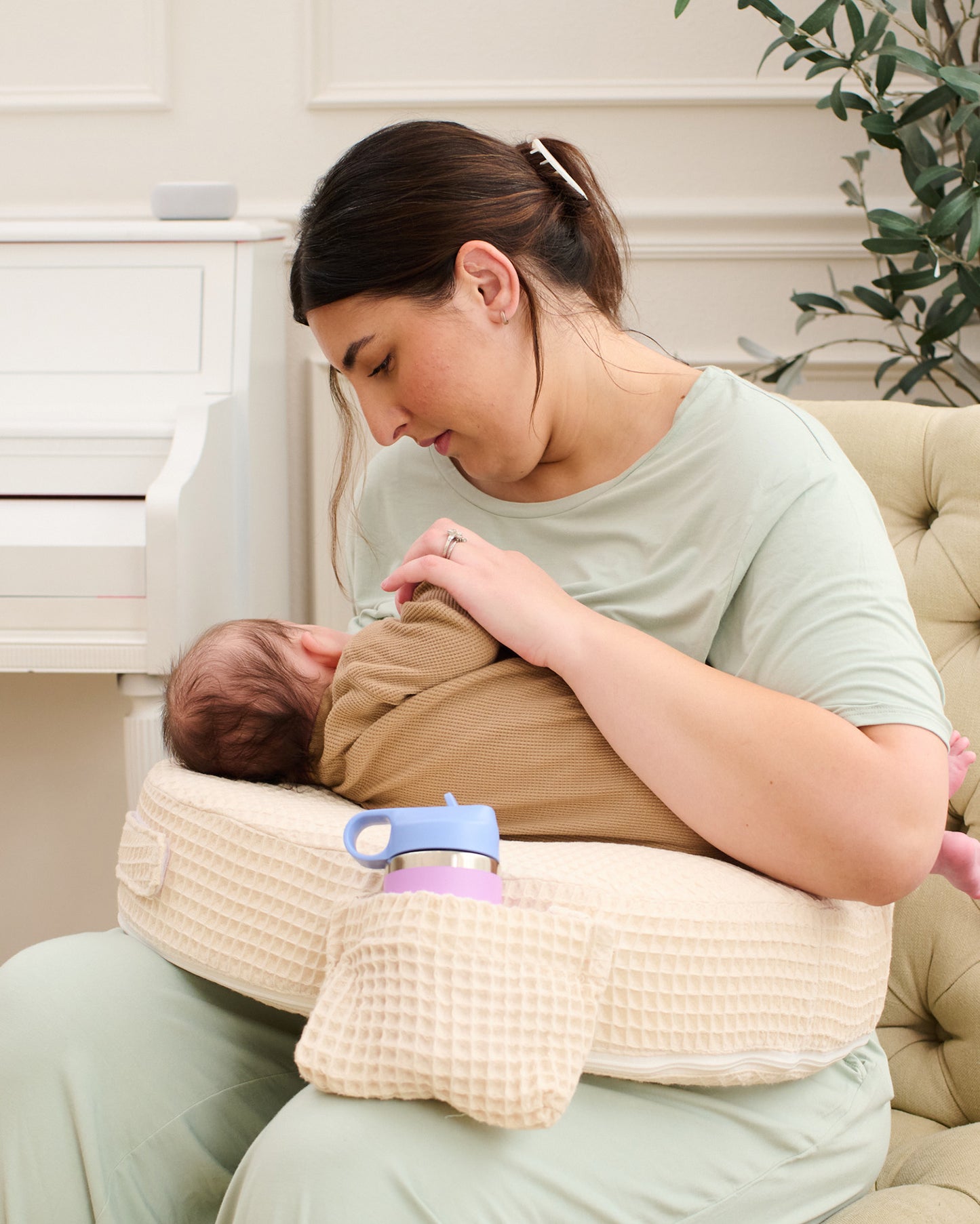 Woman breastfeeding a baby using the My Brest Friend - Super Deluxe Nursing Pillow in Oatmeal Waffle in a home setting.