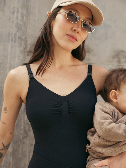 Model outside holding baby and wearing the Sublime®️ Bamboo Maternity & Nursing Bodysuit. @model_info:Lyn is wearing a Small.