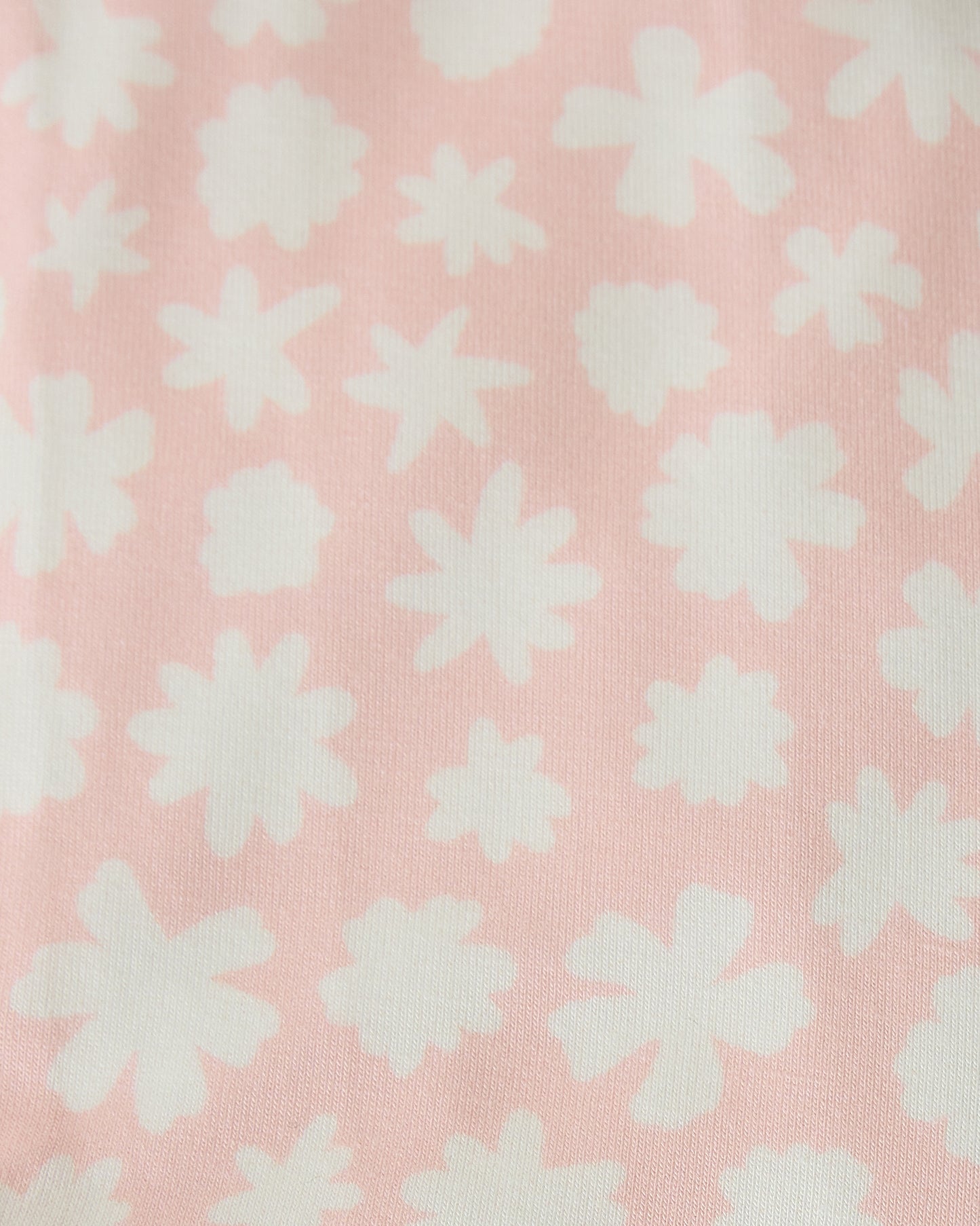 Close up swatch of Pink Chamomiles pattern of Baby Onesie Two-Pack in Cream & Pink Chamomiles on a beige background