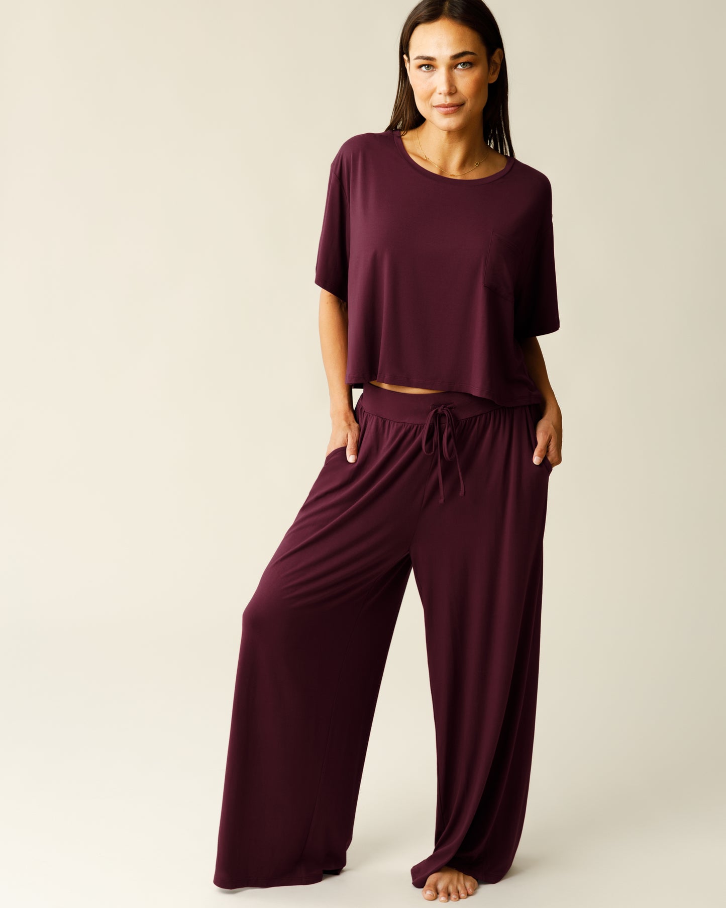 Front view of woman wearing the Aria Bamboo Casual Cropped Short Sleeve Top in Deep Burgundy with matching Aria Bamboo Casual Lounge Pant, and hands in pockets