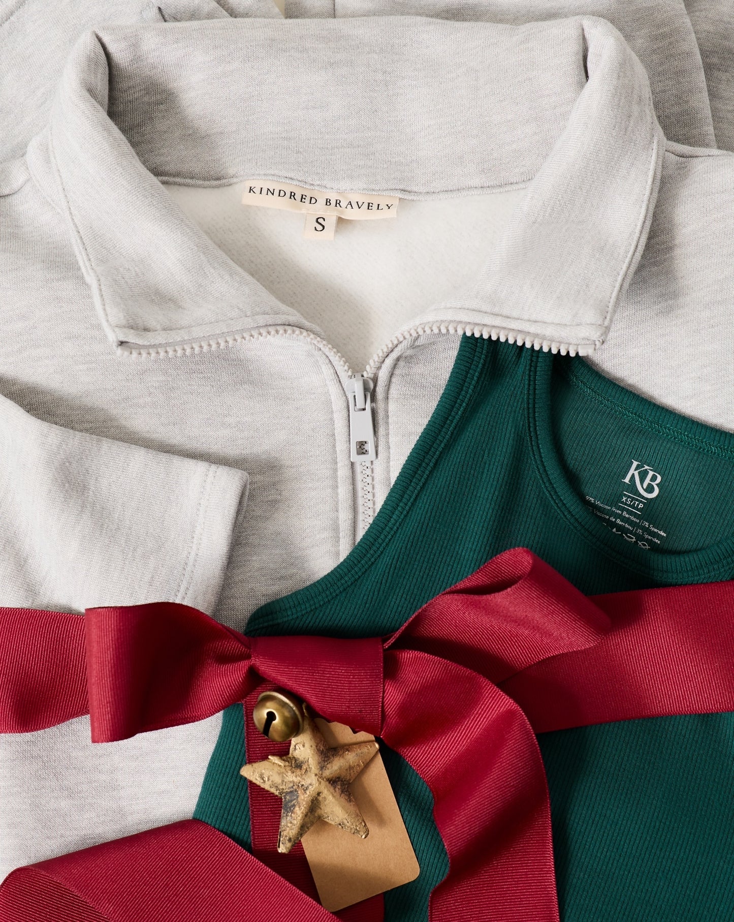 Gray zip-up hoodie with green tank and red ribbon, featuring a brand label.