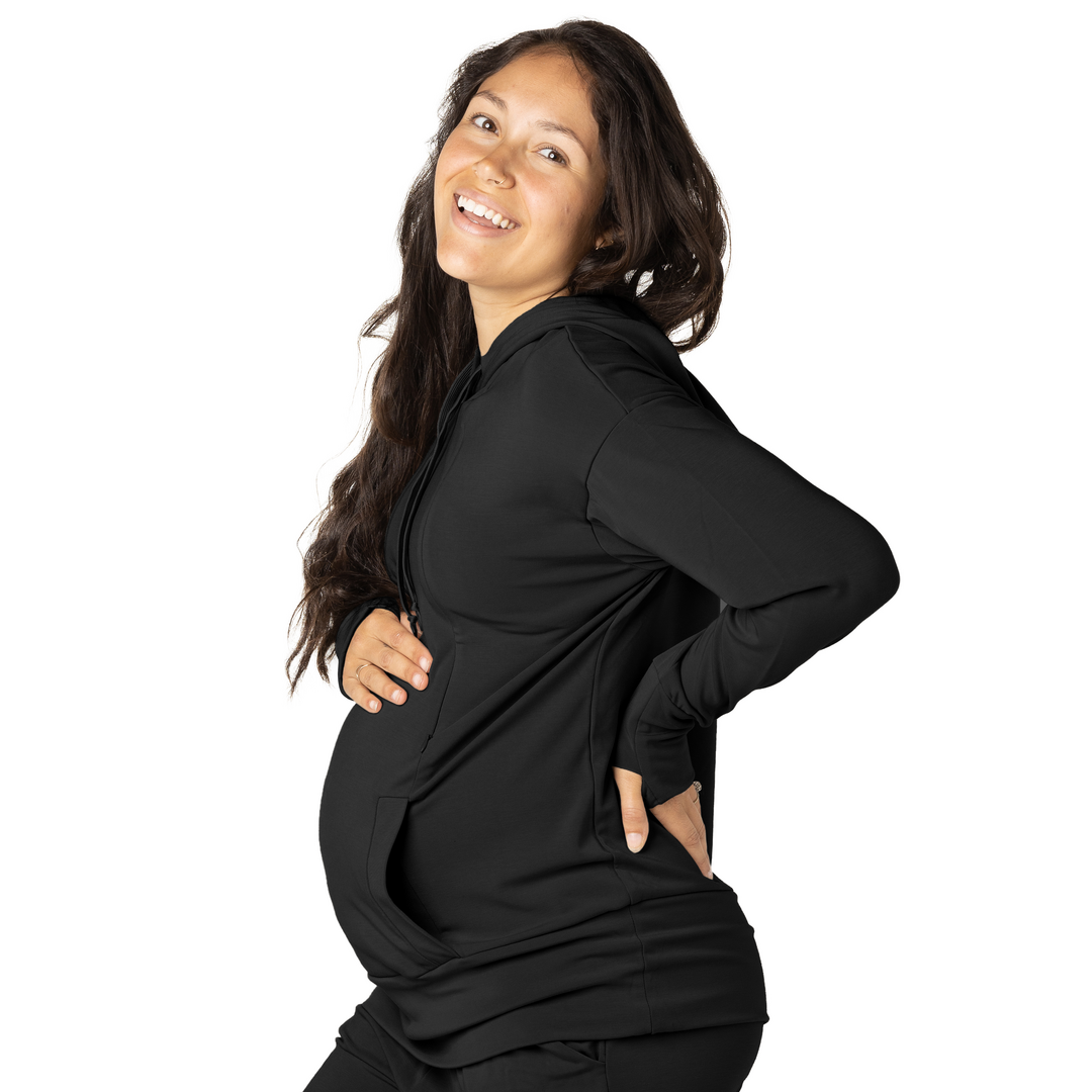 Model holding onto her pregnant belly while wearing the Bamboo Nursing Hoodie in Black