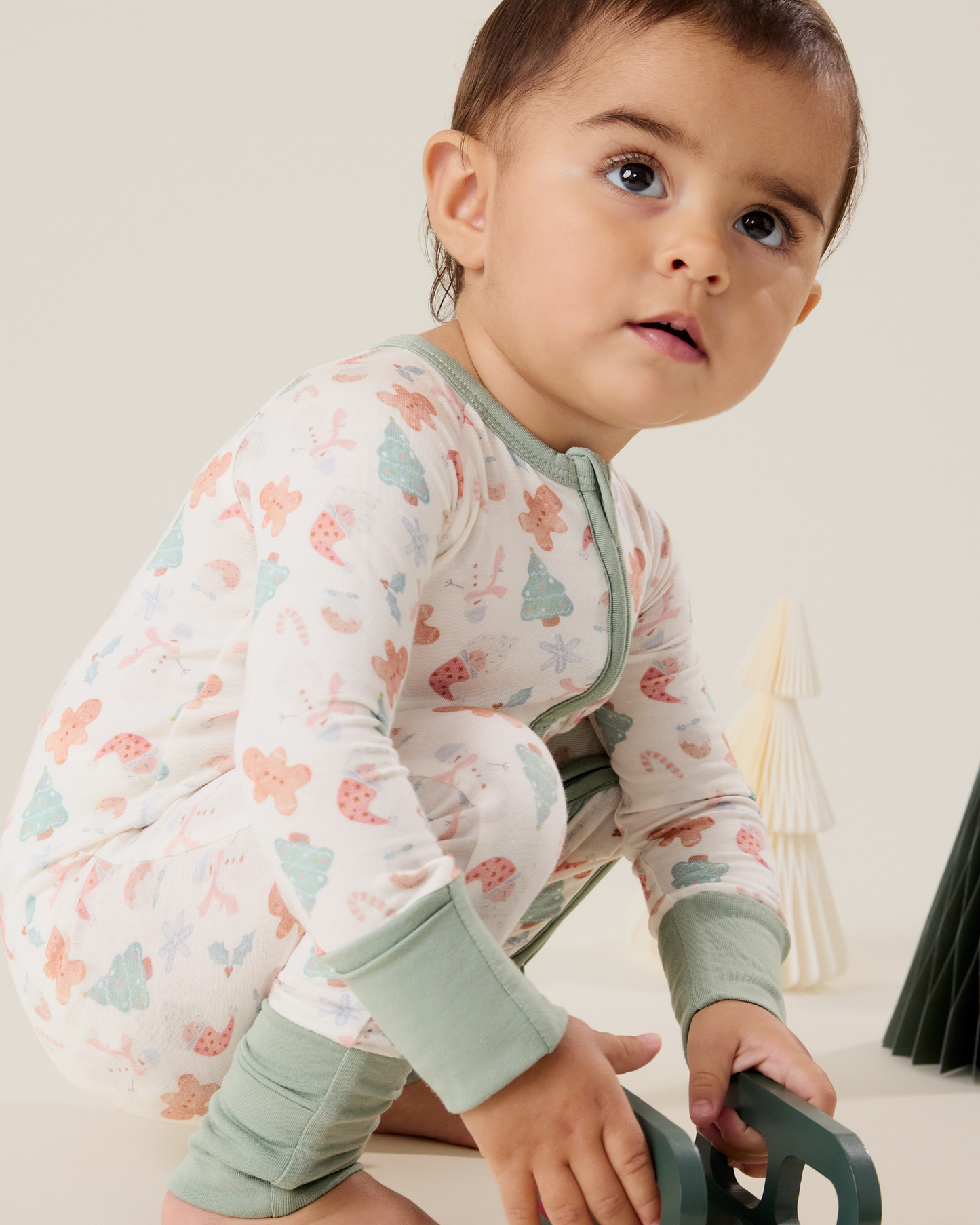 Baby wearing the Bamboo Baby Pajama in Cozy Holiday pattern with soft light green trim