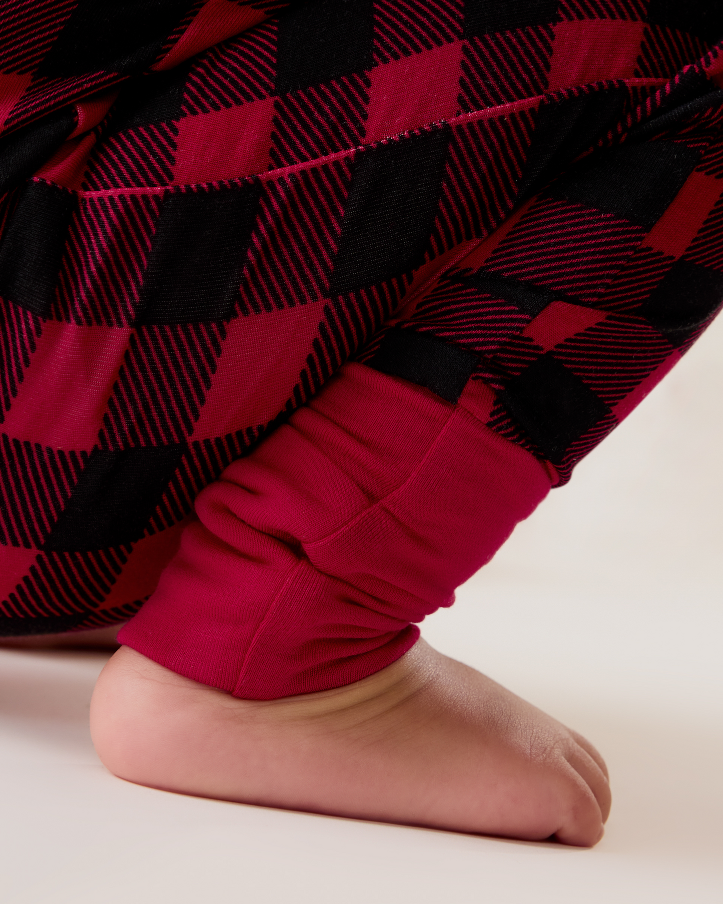 Baby wearing the Bamboo Baby Pajama in Red Plaid, showing ankle cuff detail