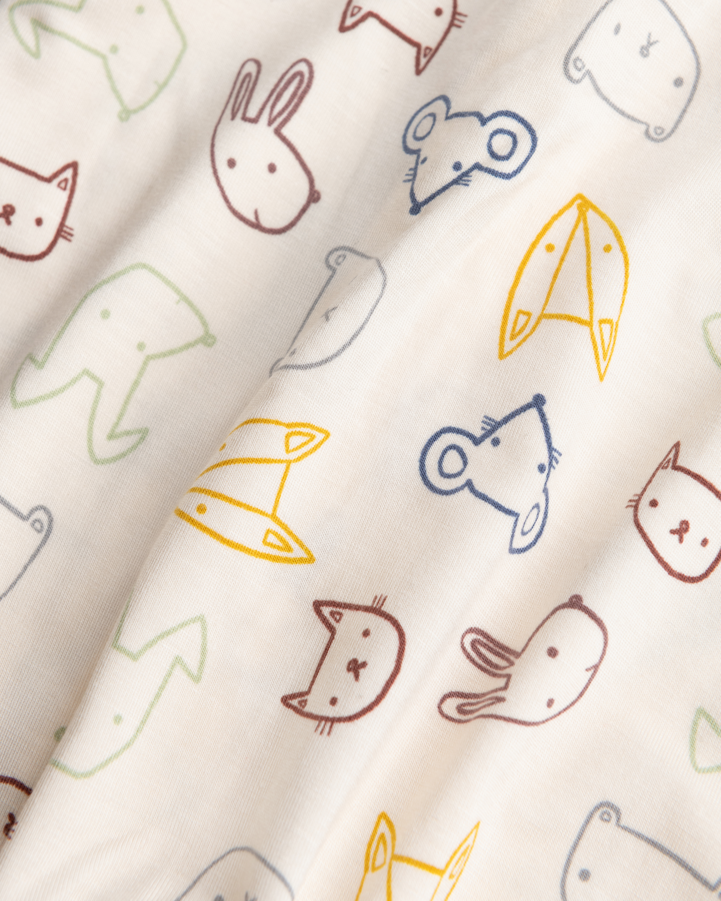 Close-up of Bamboo Baby Pajamas in Critter Crew on a beige background
