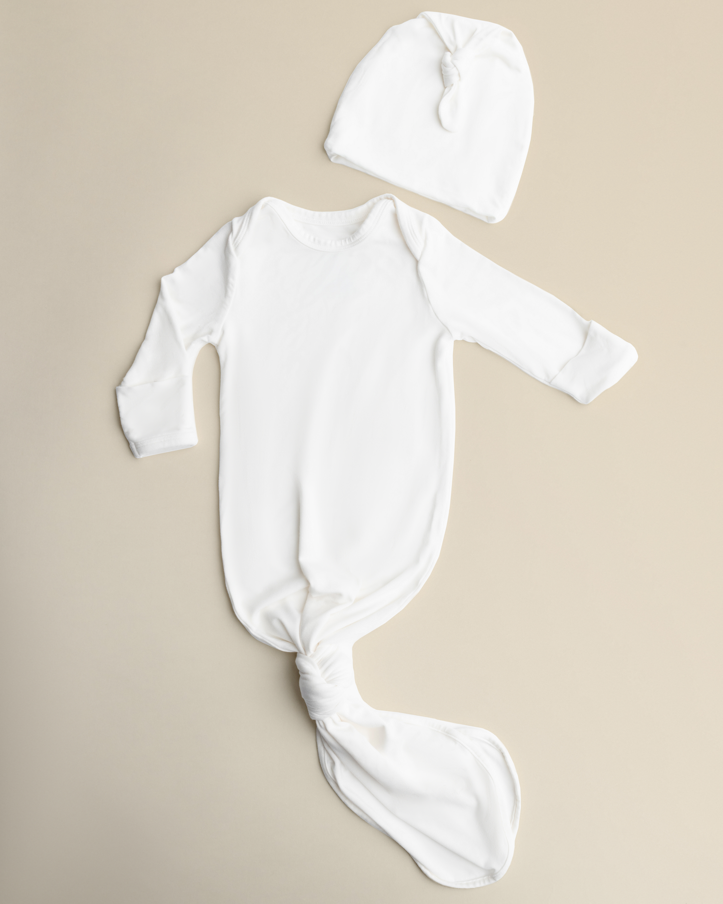 Bamboo Knotted Baby Gown in Pearl on a beige background