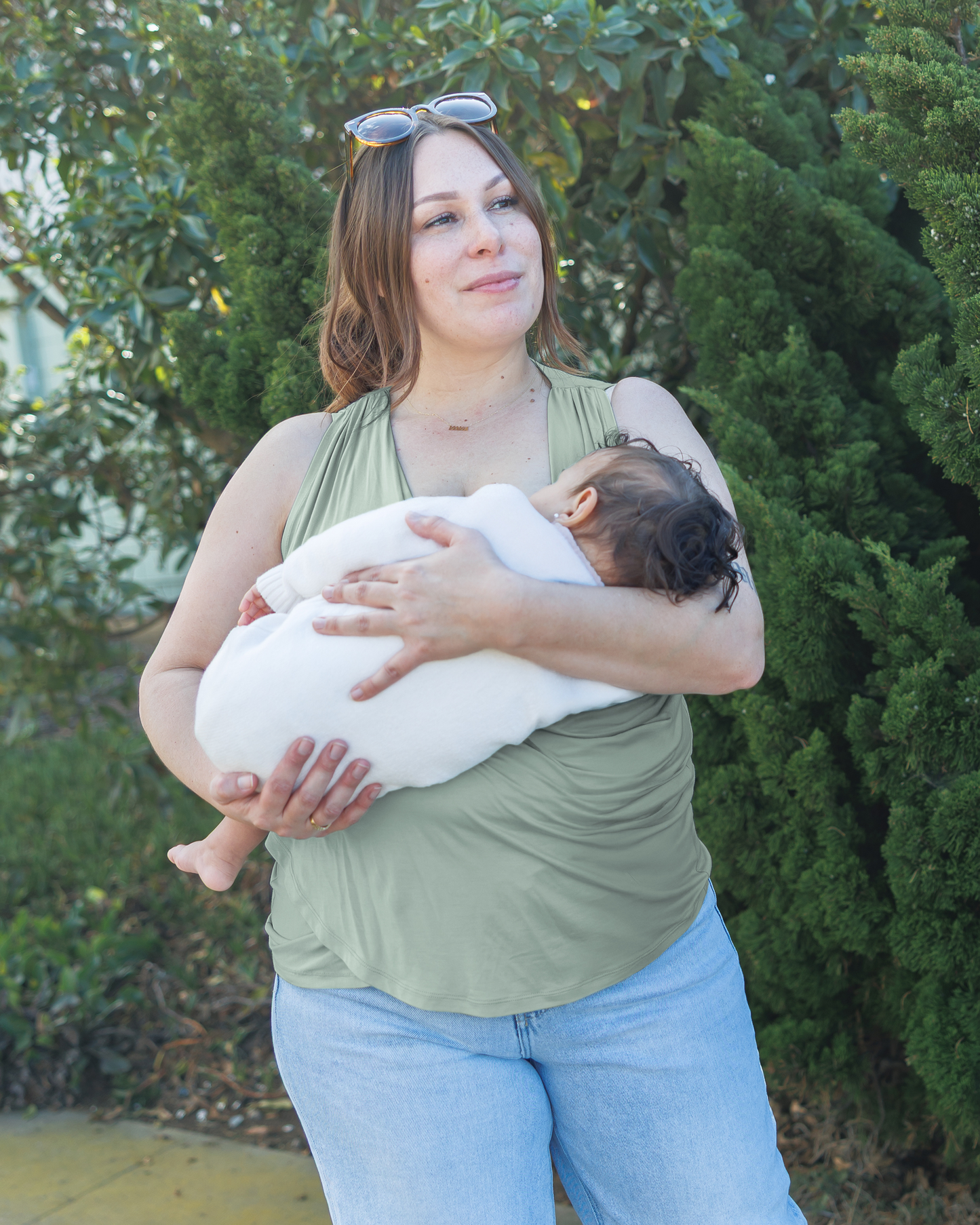 Front view of model holding and nursing baby, wearing the Bamboo Draped Nursing Tank in Aqua Mist