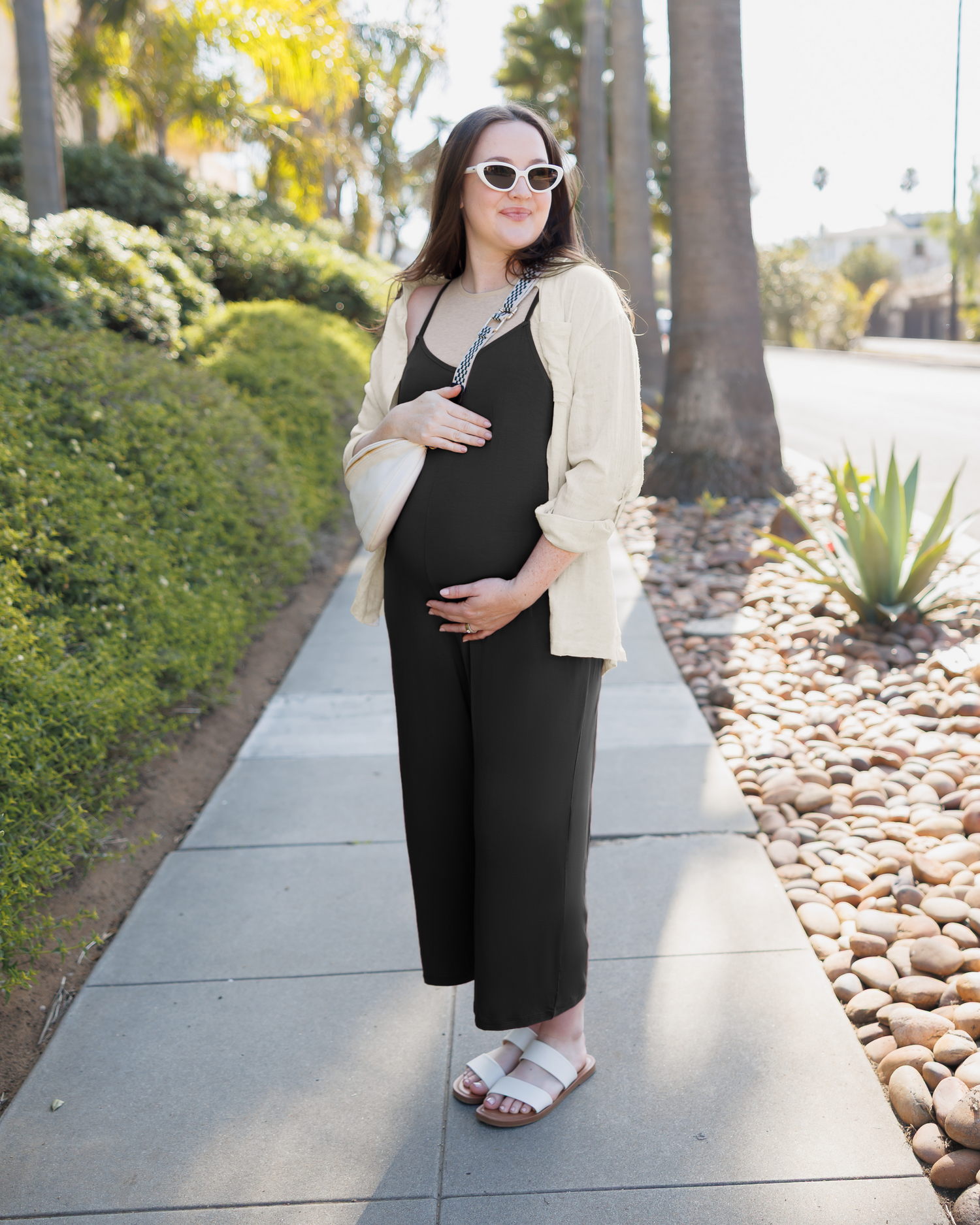 Model wearing the Charlie Maternity & Nursing Romper in Black, paired with Reese Linen Oversized Button Down Shirt, sandals and crossbody bag.