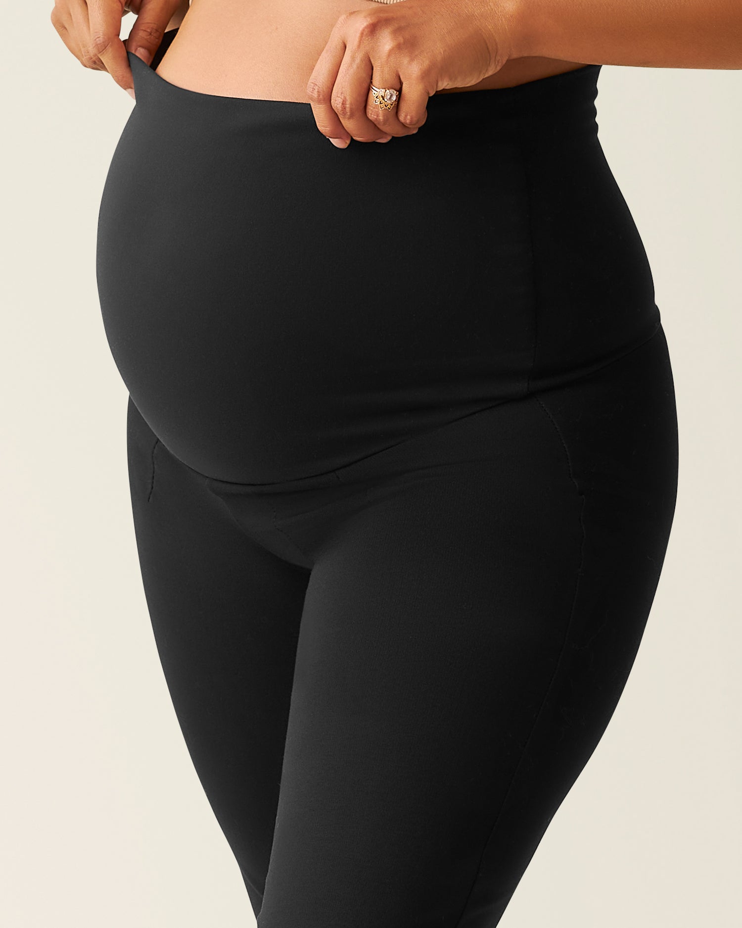 Close-up of woman wearing the black Maternity Ponte Flare Pant, showing belly panel