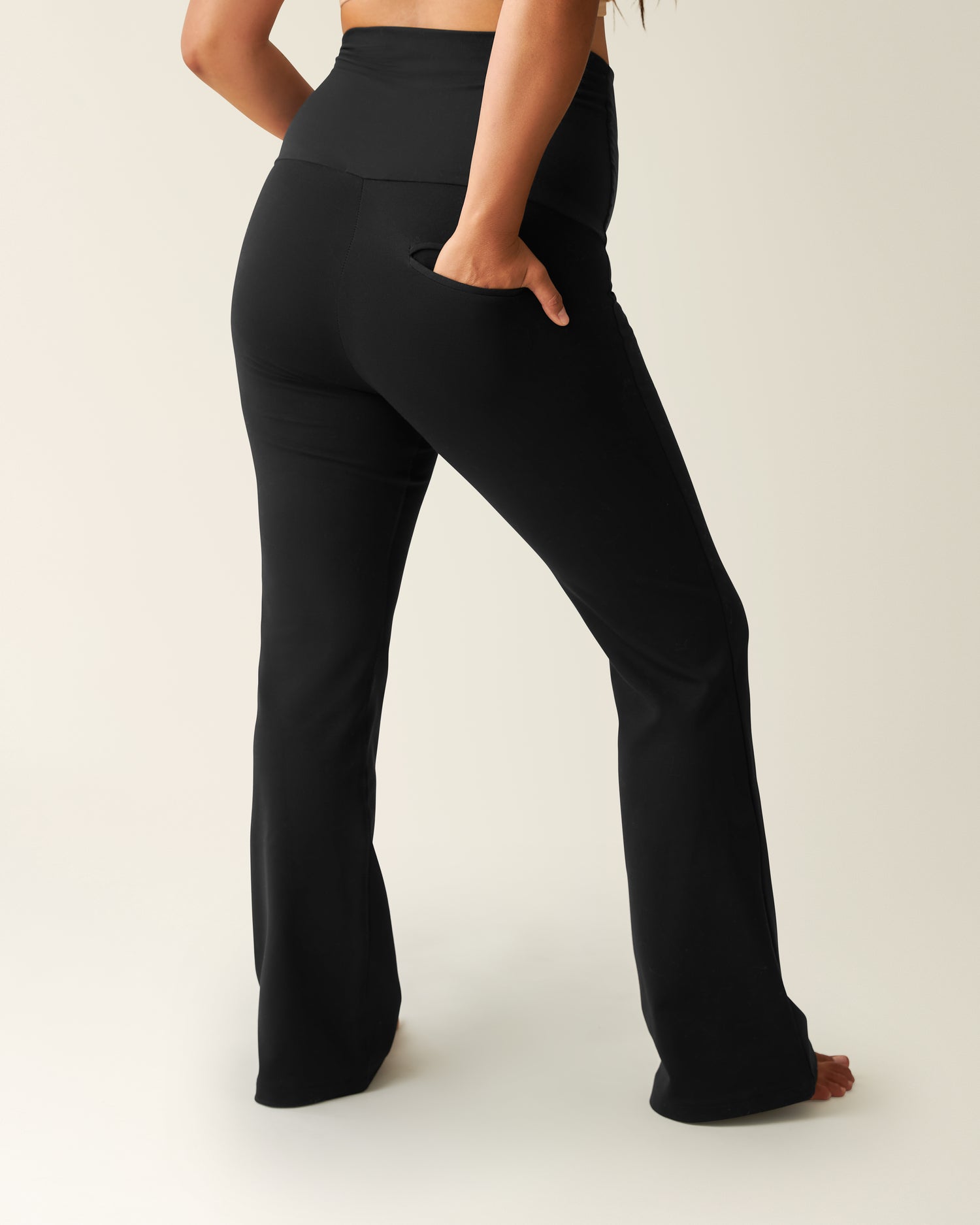 Woman wearing the black Maternity Ponte Flare Pant, showing back pocket