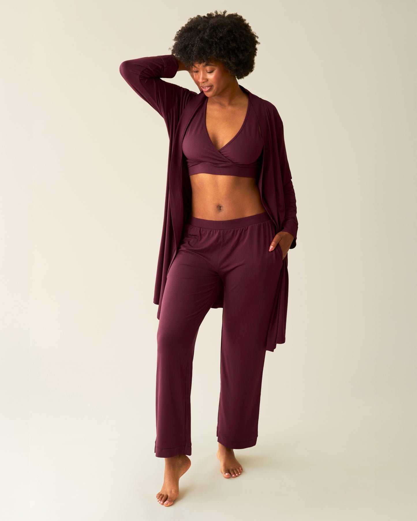 Woman wearing the Clea Bamboo Robe in Deep Burgundy, open and paired with matching French Terry Bra and Clea Bamboo Long Sleeve Pajama Set bottoms