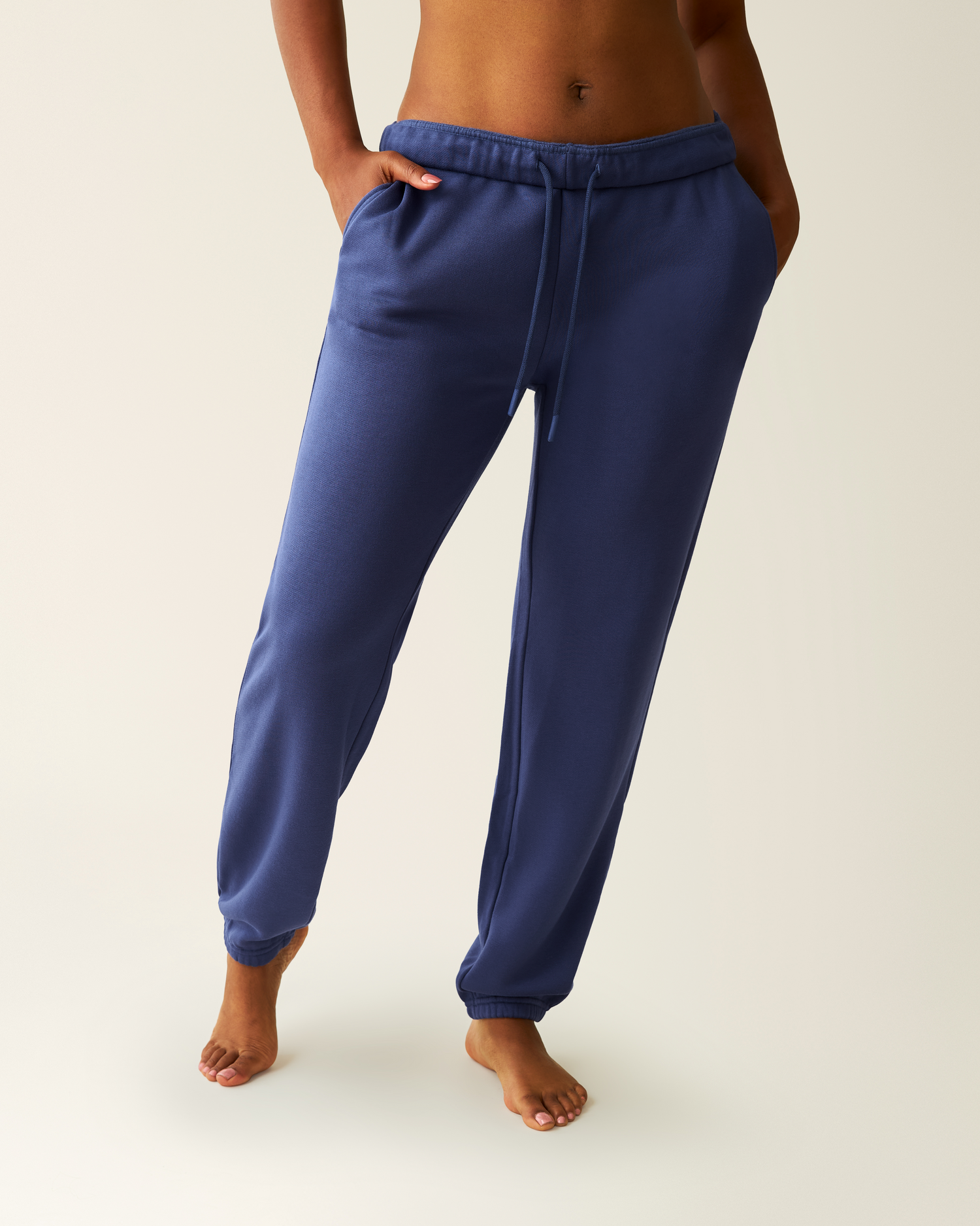 Close-up of woman wearing the Cloud Fleece Jogger in Deep Blue, with hands in pockets@model_info:Kyra is 5'9" and wearing a Small.
