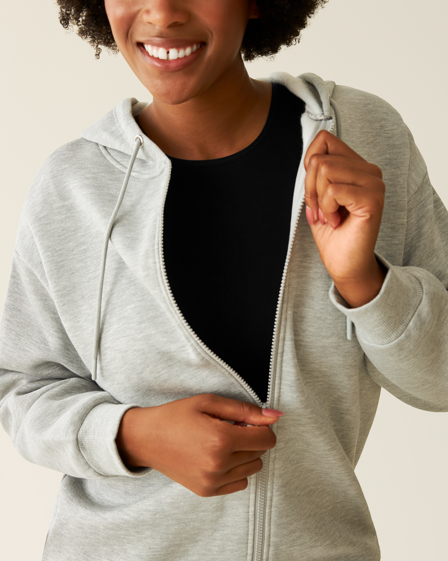 Close-up of woman wearing the Cloud Fleece Oversized Hoodie in Grey Heather showing unzipping from the top