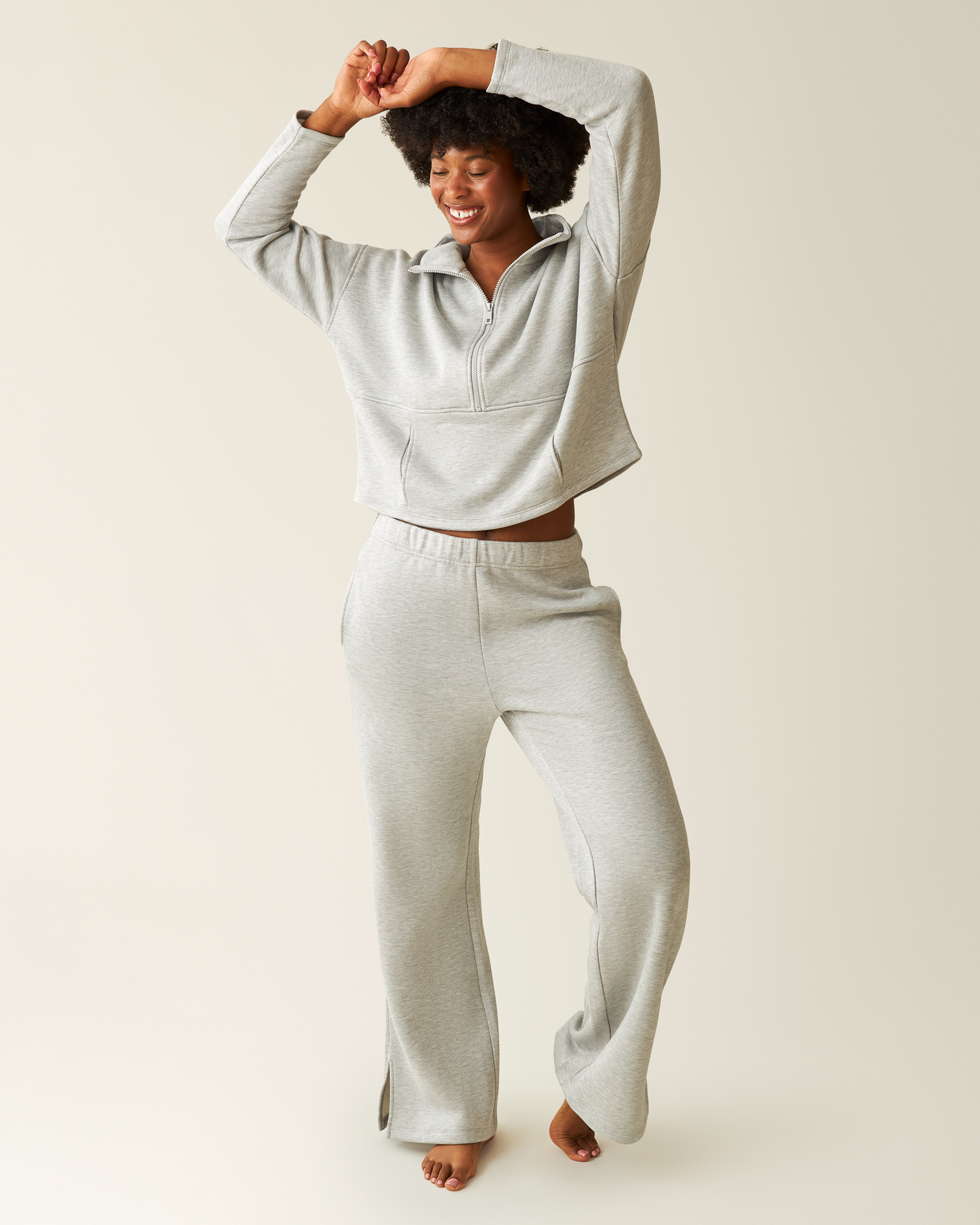 Woman wearing a heather grey Cloud Fleece Half-Zip Pullover and Sweatpant on a beige background