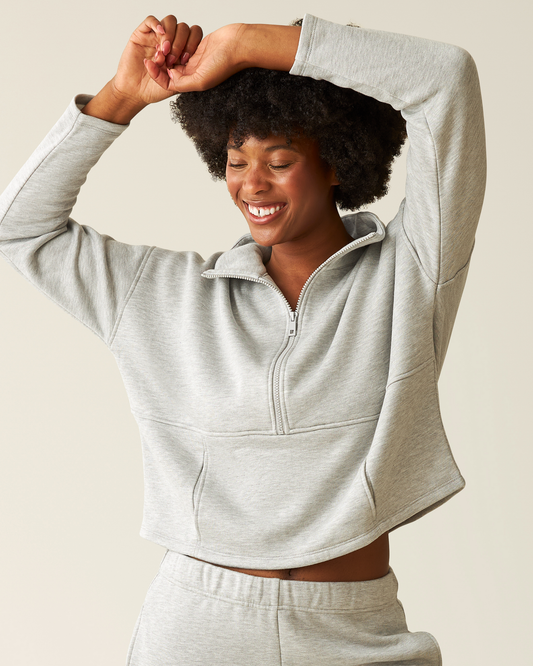 Woman wearing the Cloud Fleece Half Zip Pullover in Grey Heather with arms overhead@model_info:Kyra is wearing a Small.