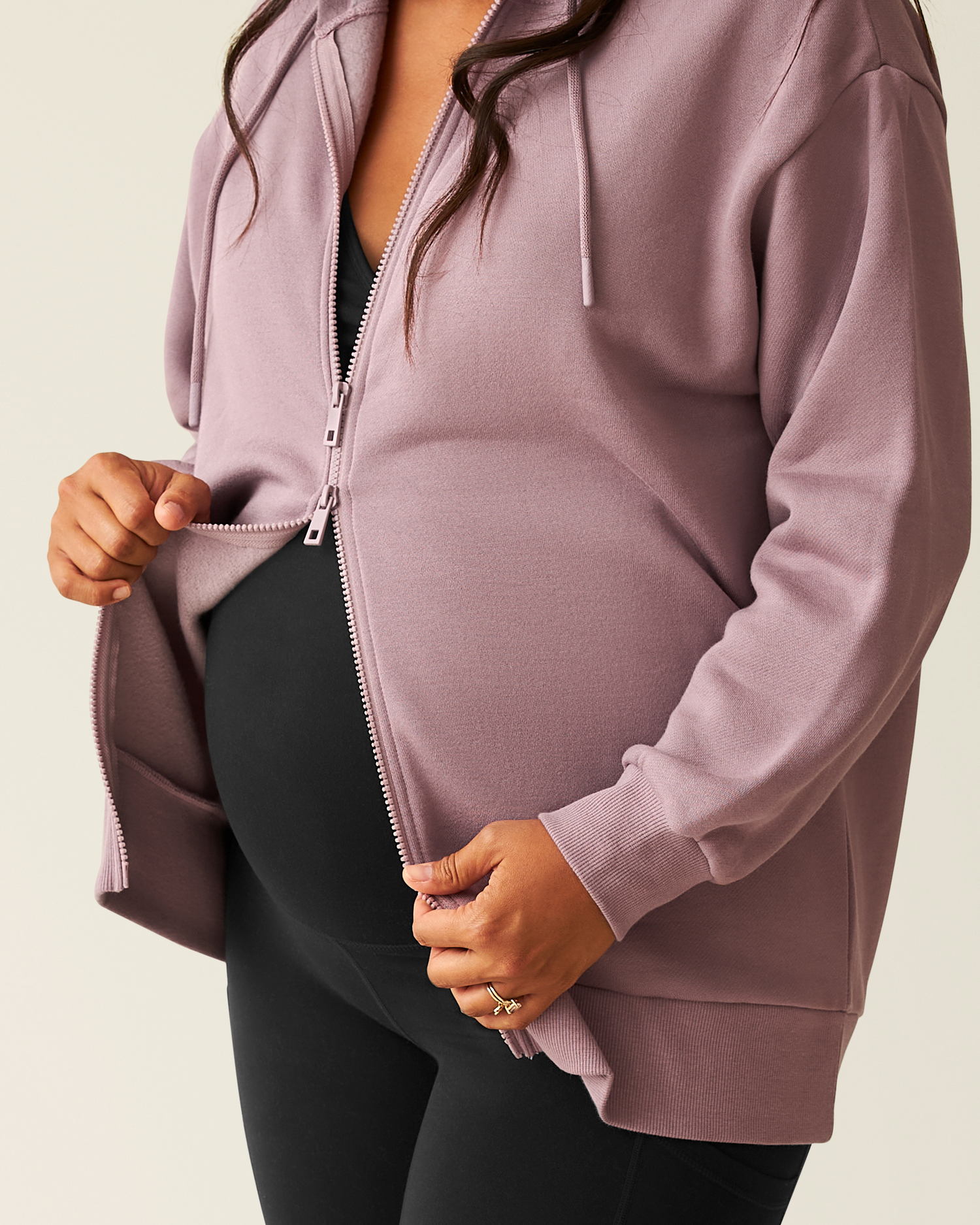 Close-up of woman wearing the Cloud Fleece Oversized Hoodie in Dusty Mauve with bottom of hoodie unzipped