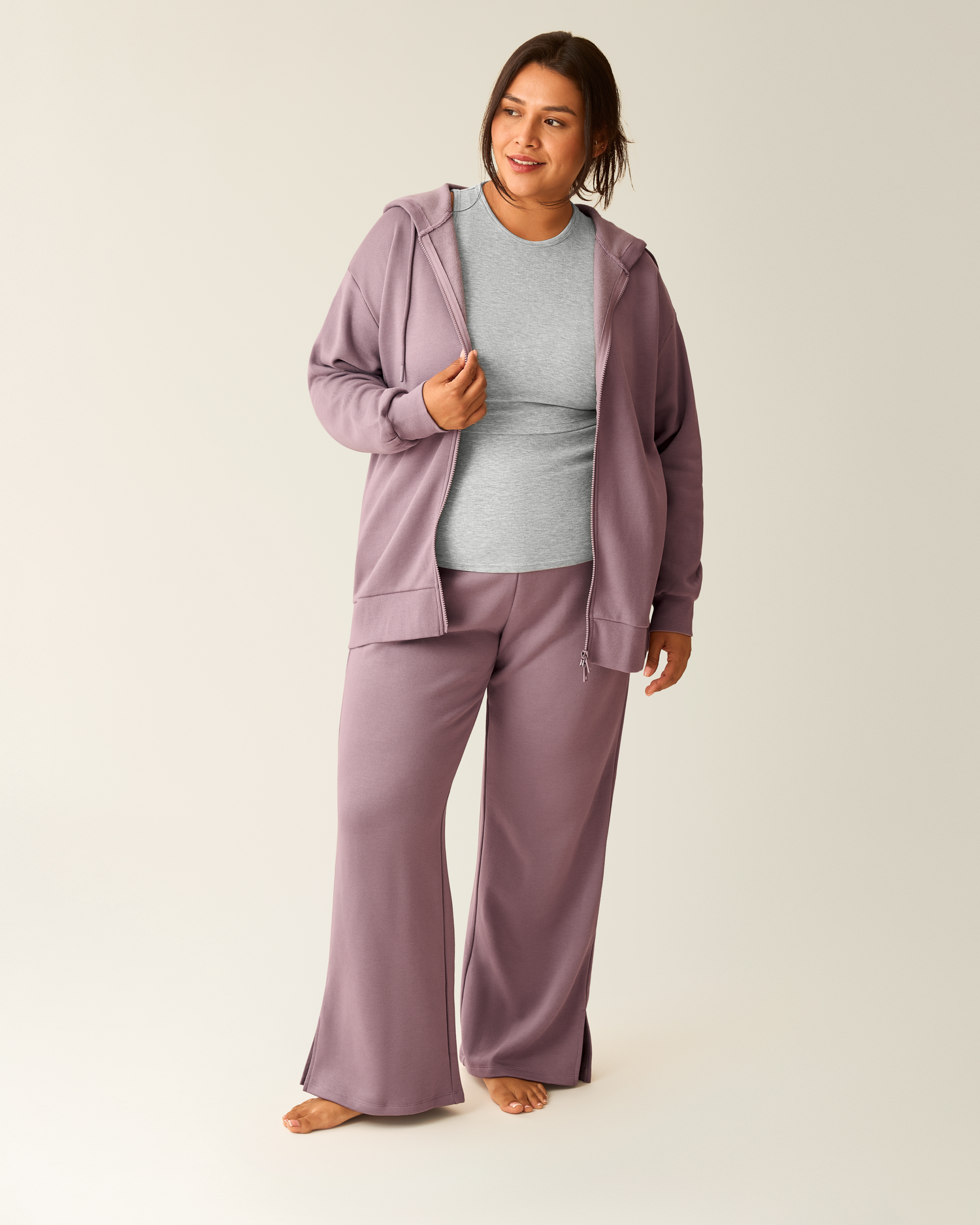 Woman wearing dusty mauve Cloud Fleece Oversized Hoodie unzipped, paired with matching Cloud Fleece Sweatpant and grey shirt underneath on a beige background@model_info:Victoria is 5'10" and wearing a 1X.