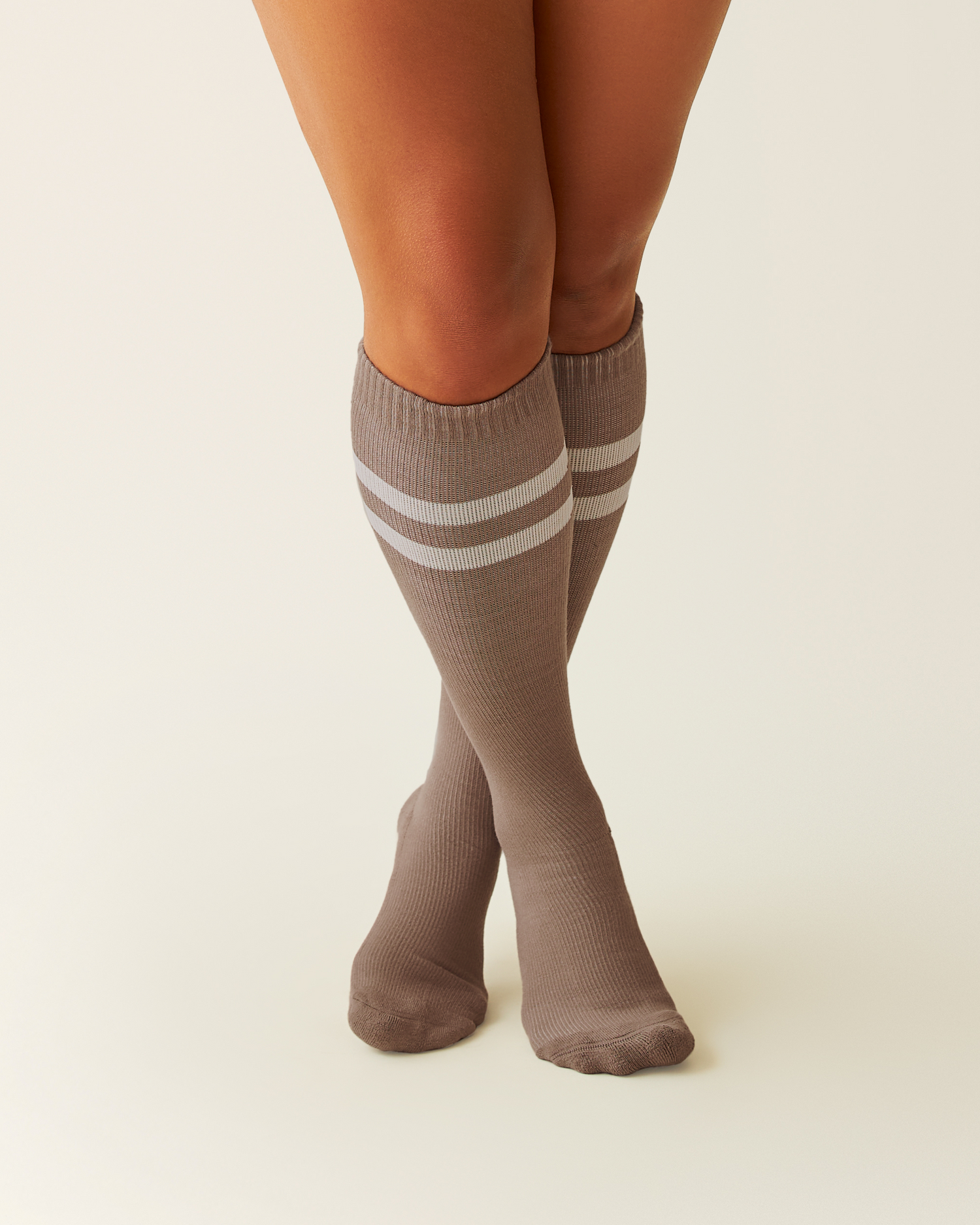Premium Maternity Compression Socks in Taupe with white stripes worn by a person on a beige background