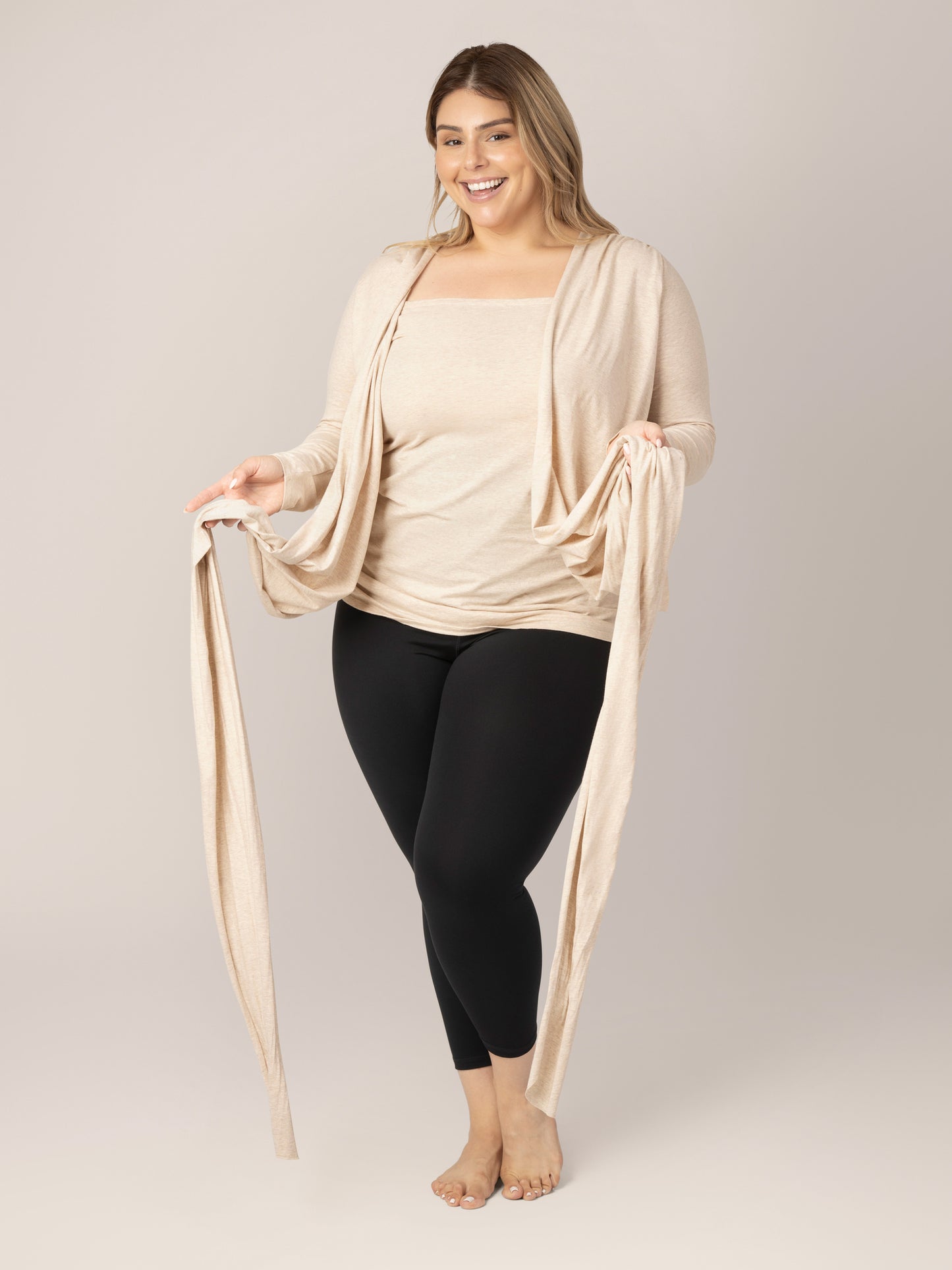 Model wearing the Organic Cotton Skin to Skin Long Sleeve Wrap Top in Oatmeal Heather, showing top completely unwrapped exposing inner pane and holding straps.
@model_info:Vanessa is wearing a Large.