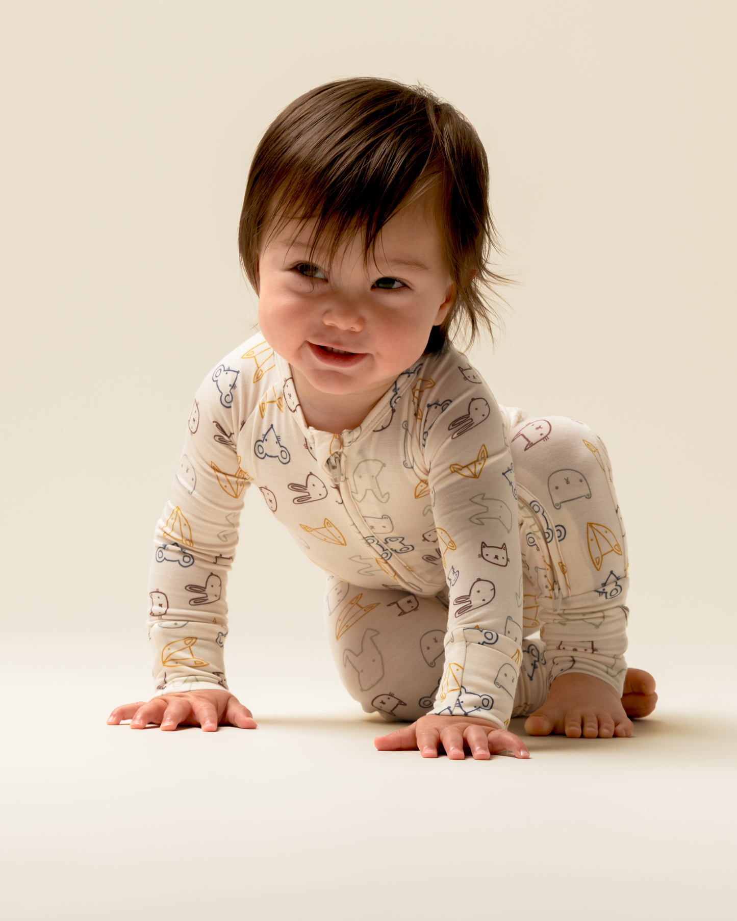 Baby wearing Bamboo Baby Pajamas in Critter Crew on a plain background