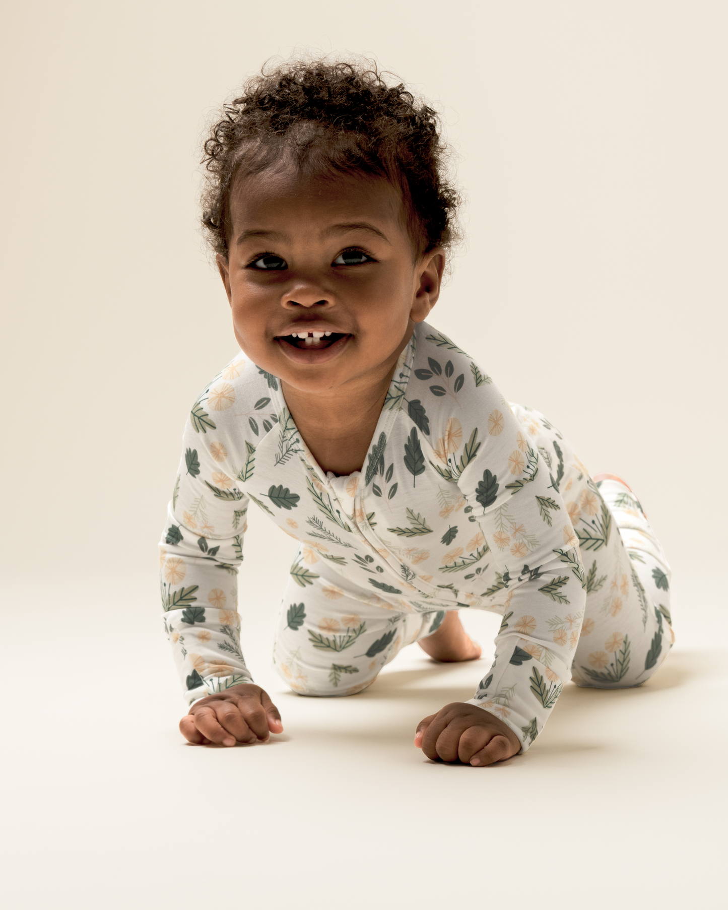 Baby crawling on a light background wearing Bamboo Baby Pajamas in Honey Dandelion