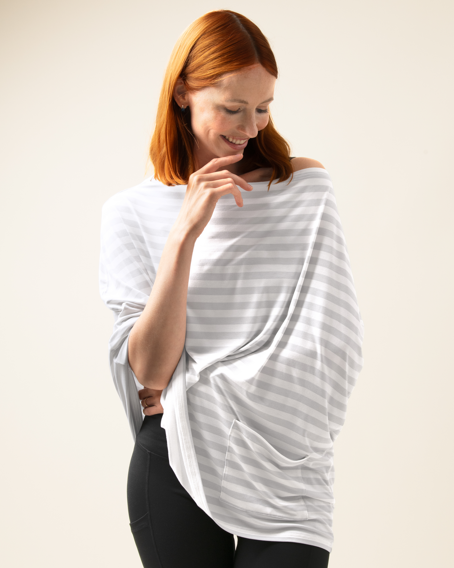 Woman wearing Bamboo Multi-Use Nursing Cover in Grey Stripe and black pants on a plain background@model_info:Anna is 5'10".