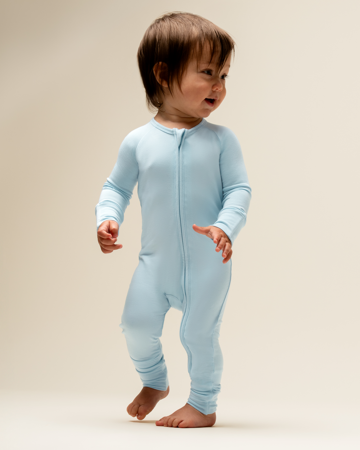 Baby wearing Bamboo Baby Pajamas in French Blue a beige background@model_info:Mosey is wearing 3-6 months.
