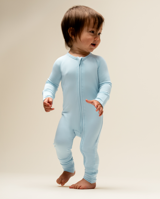 Baby wearing Bamboo Baby Pajamas in French Blue a beige background@model_info:Mosey is wearing 3-6 months.