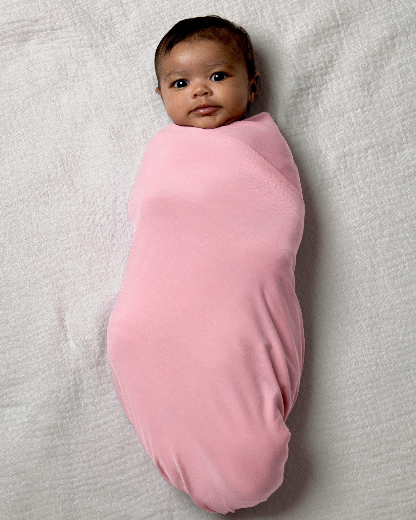 Baby wrapped in Bamboo Swaddle Blanket in Light Mauve on a light gray background@model_info:Luna is 6 weeks old.