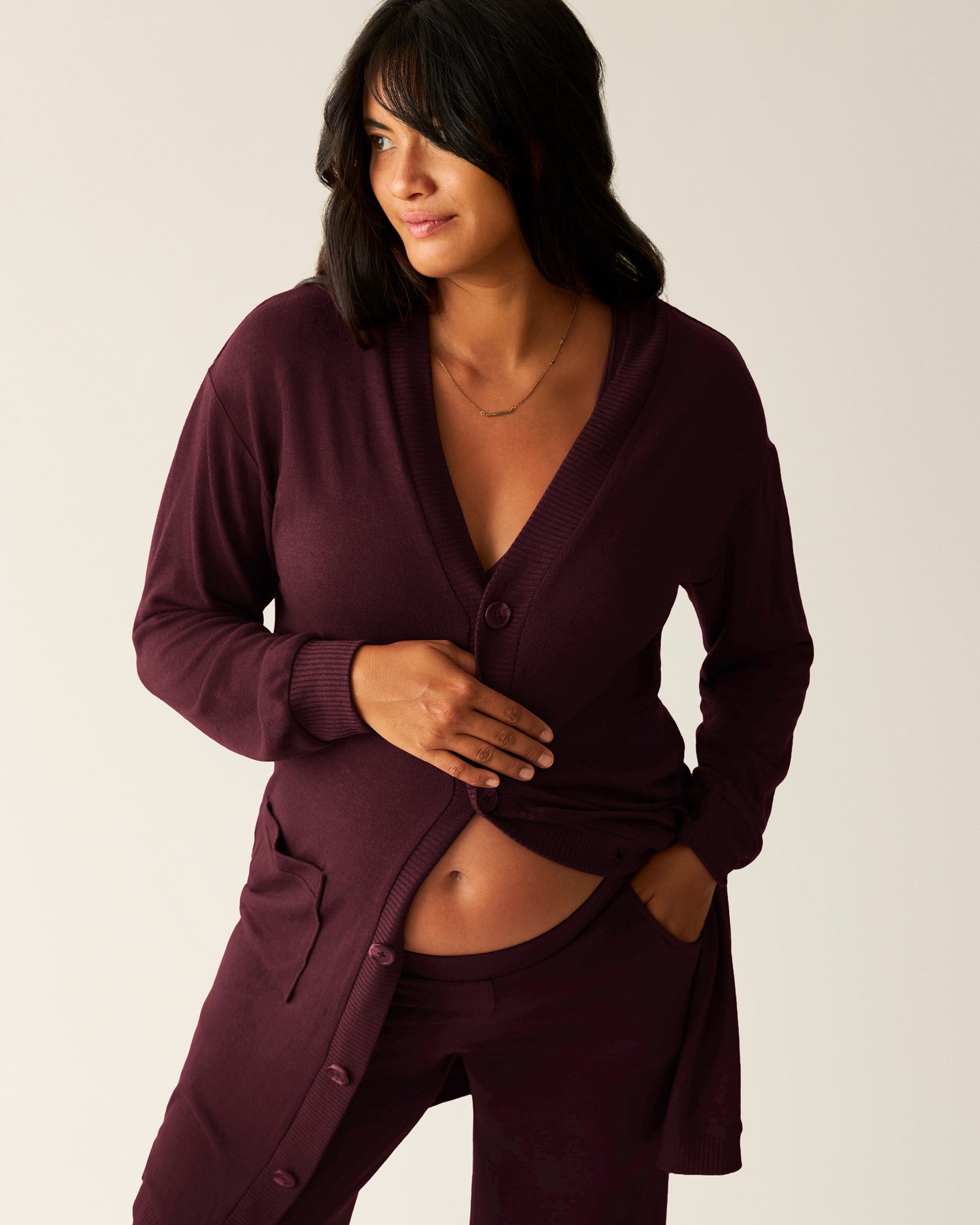 Front view model wearing CozyKnit Long Cardigan in Deep Burgundy, with her hand on her pregnant stomach @model_info:Zoe is 5'7" and wearing a Medium.