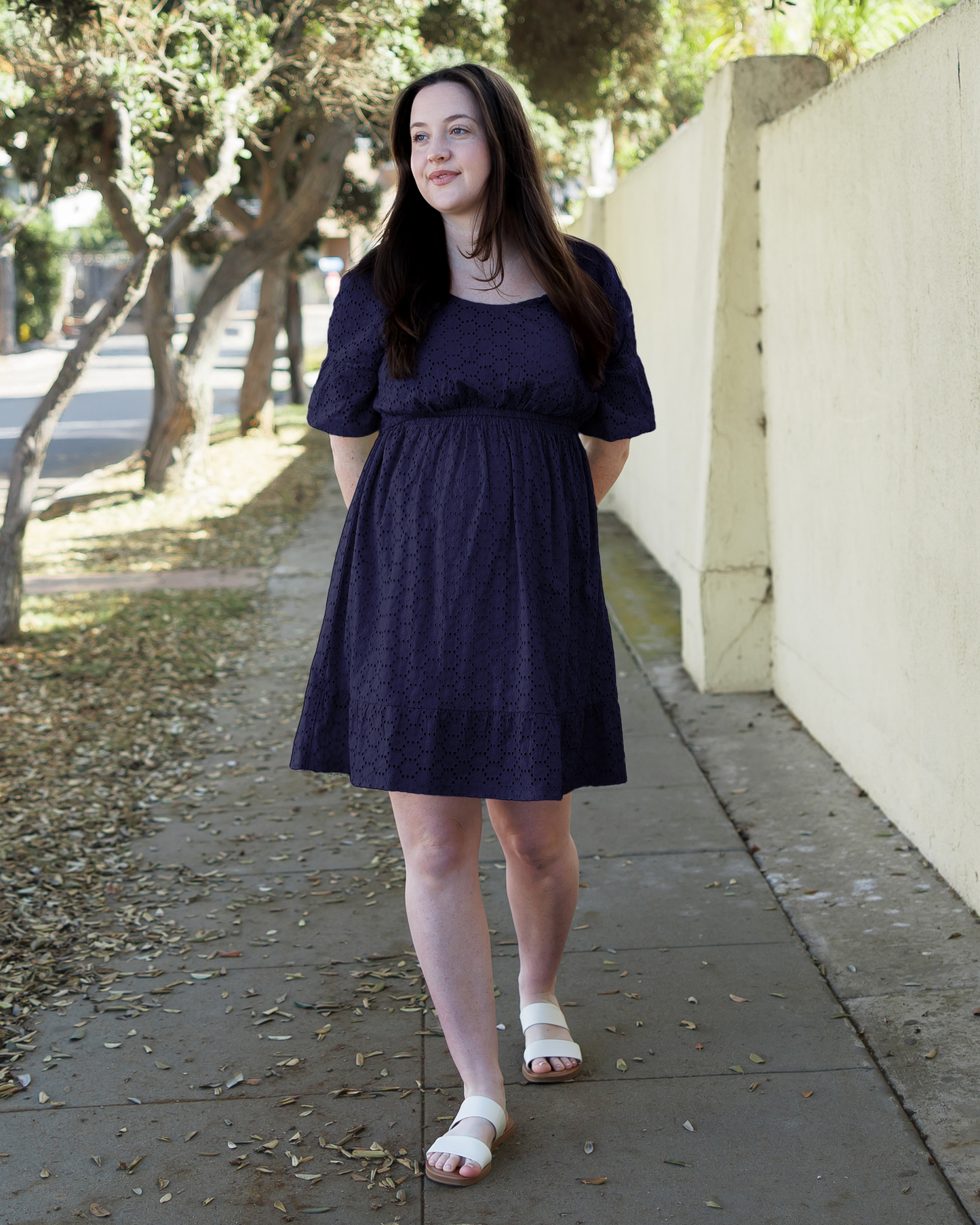 Front view of model wearing the Dahlia Eyelet Maternity & Nursing Dress in Navy@model_info:Madi is 5'6" and wearing a Medium.